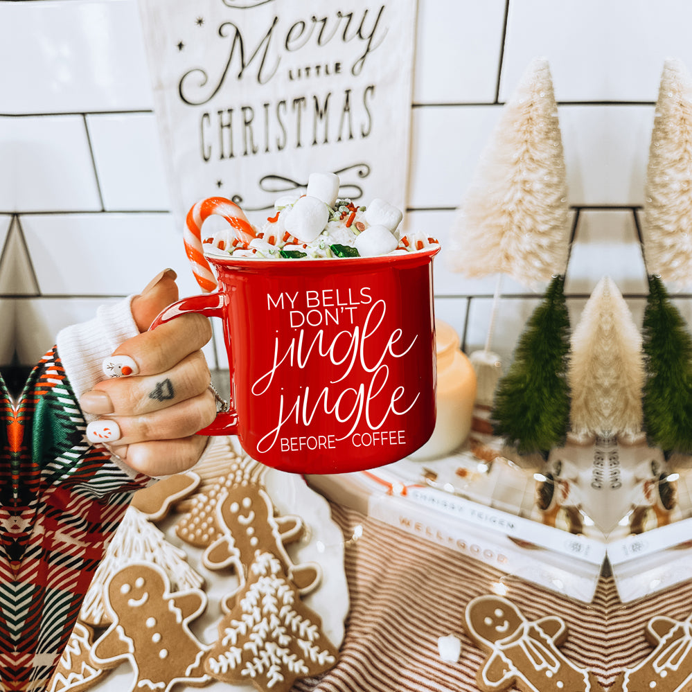 A festive Jingle Jingle Mug in red and green ceramic, featuring white lettering and a campfire style design, perfect for coffee lovers.