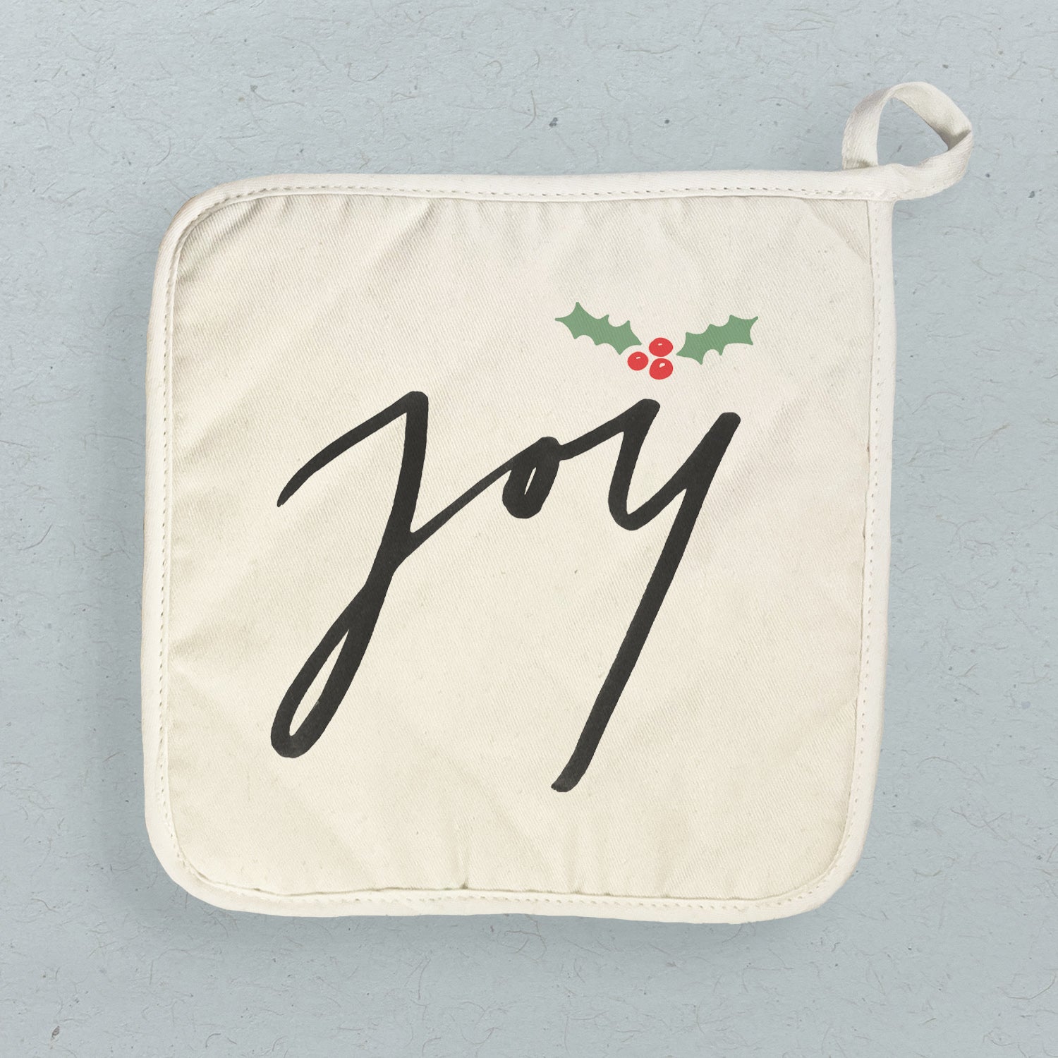 Joy Cotton Pot Holder featuring a vibrant design, made from natural cotton and terry cloth, with a convenient hanging loop.