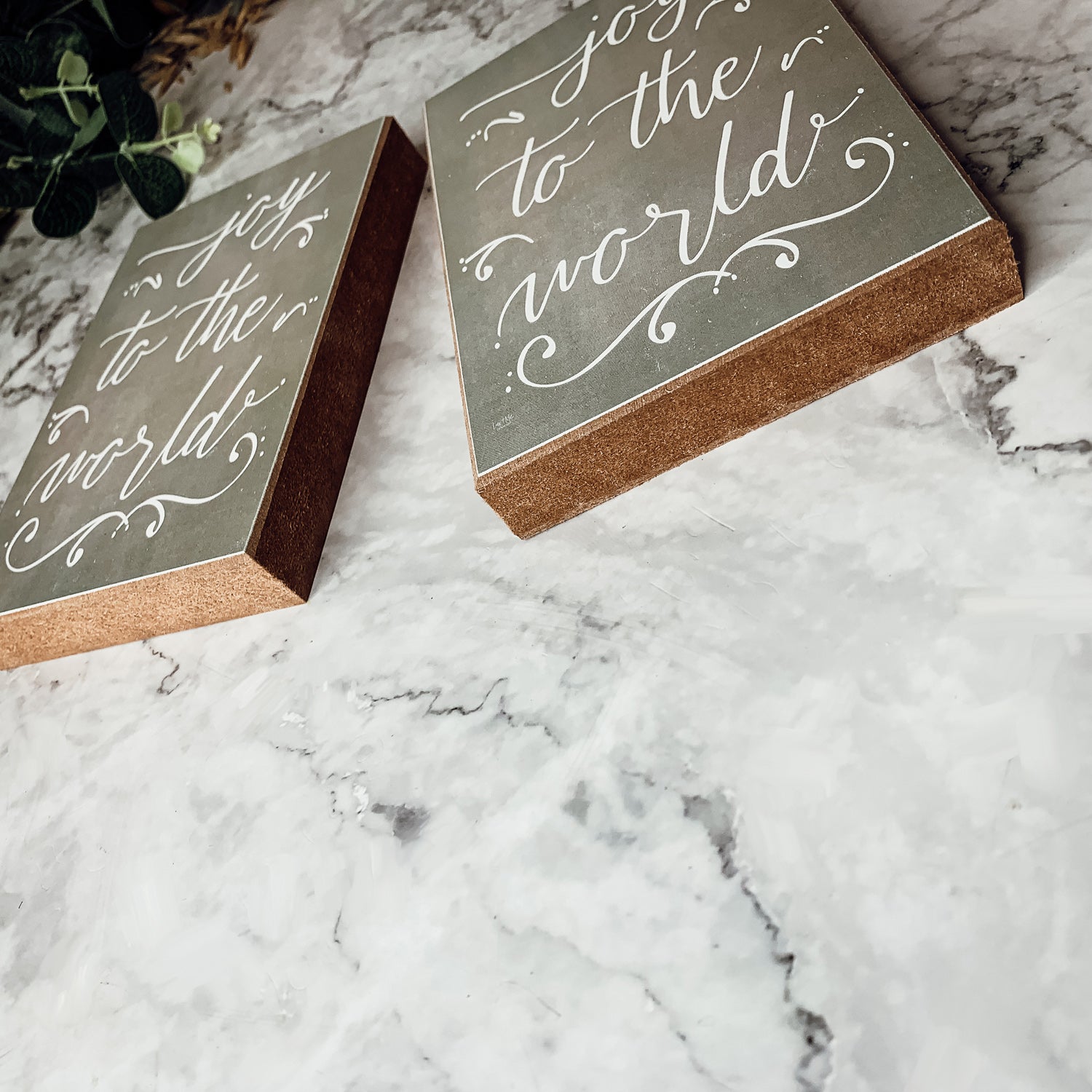 Joy To The World Sign with light gray textured background and festive text about Christmas trees and drinks.