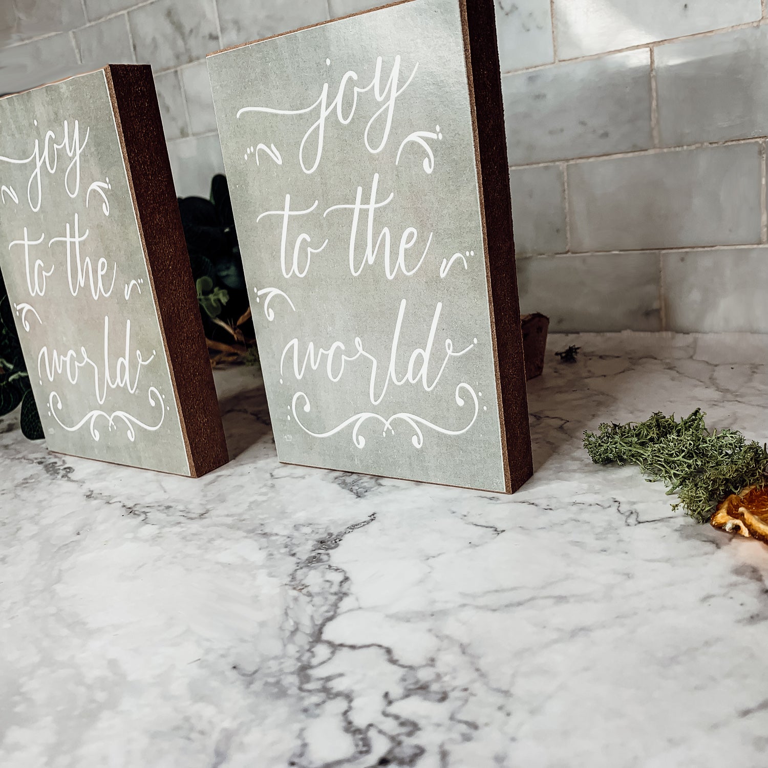 Joy To The World Sign with light gray textured background and festive text about Christmas trees and drinks.