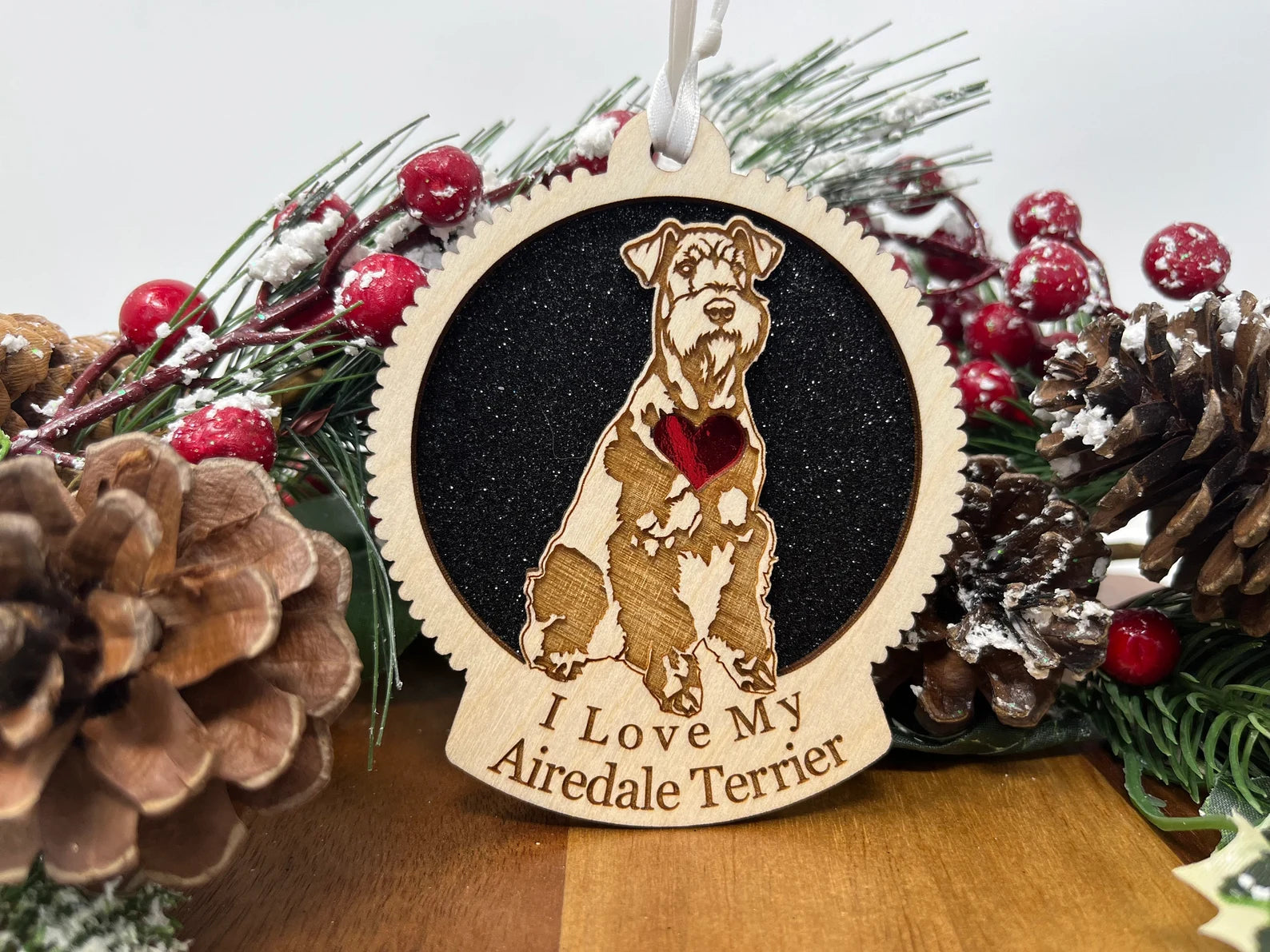 A beautifully crafted wooden ornament featuring a silhouette of an Airedale Terrier, perfect for Christmas decoration.