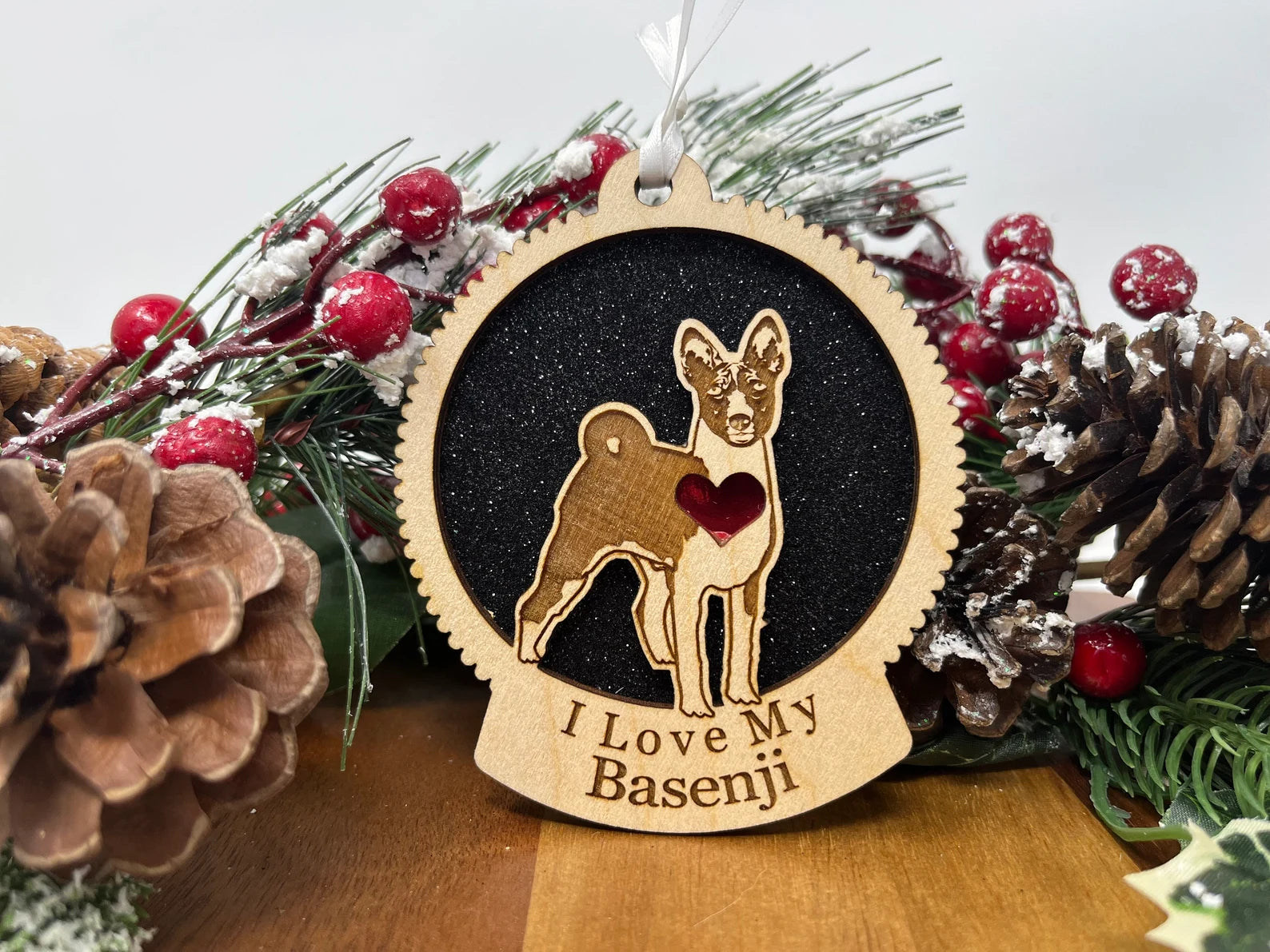 A beautifully crafted laser-cut wooden ornament featuring a Basenji silhouette, perfect for Christmas decoration.