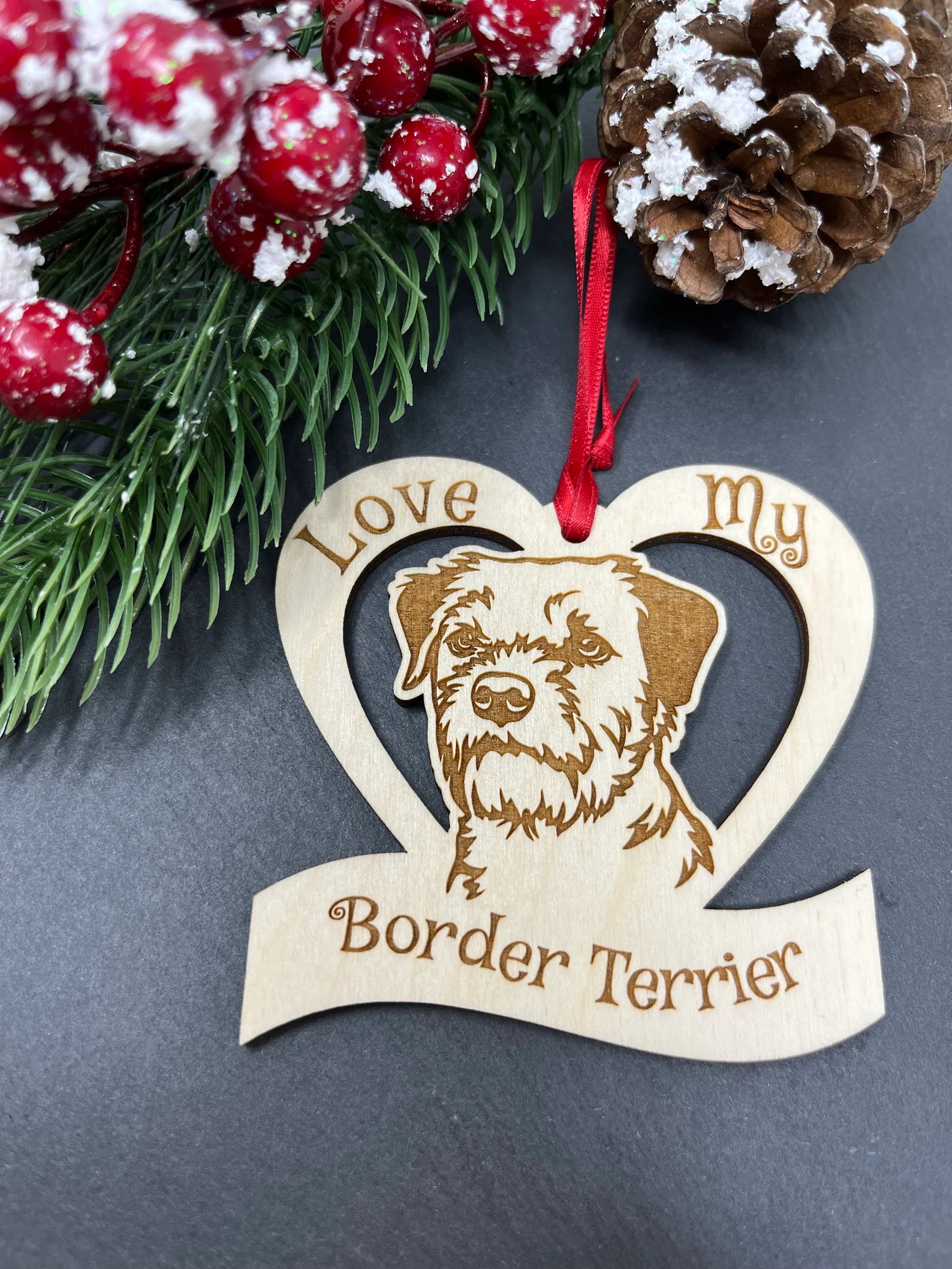 A beautifully laser engraved wooden ornament featuring a Border Terrier design, perfect for Christmas decoration.