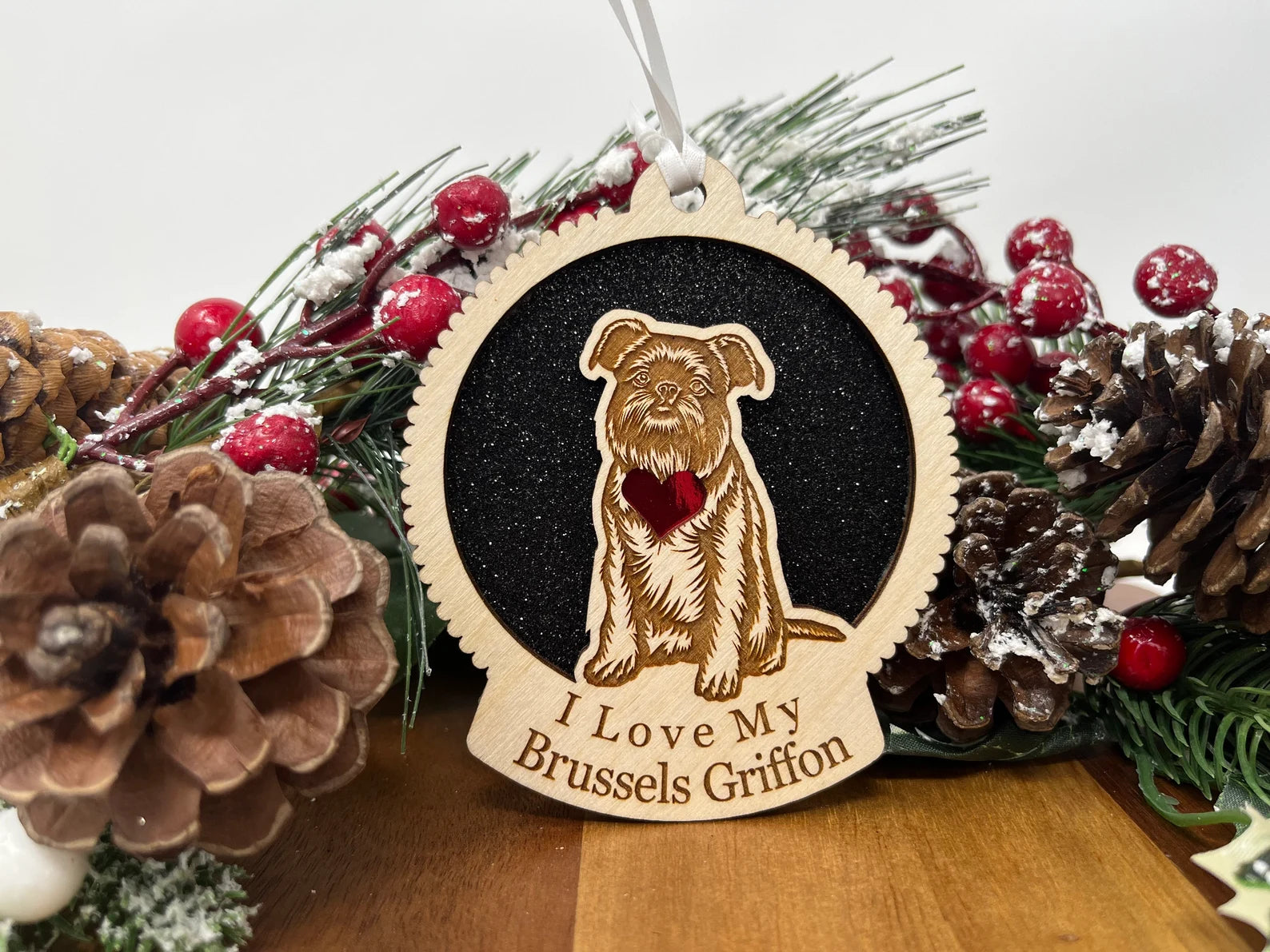 A beautifully crafted laser-cut wooden ornament featuring a Brussels Griffon silhouette, perfect for holiday decor.