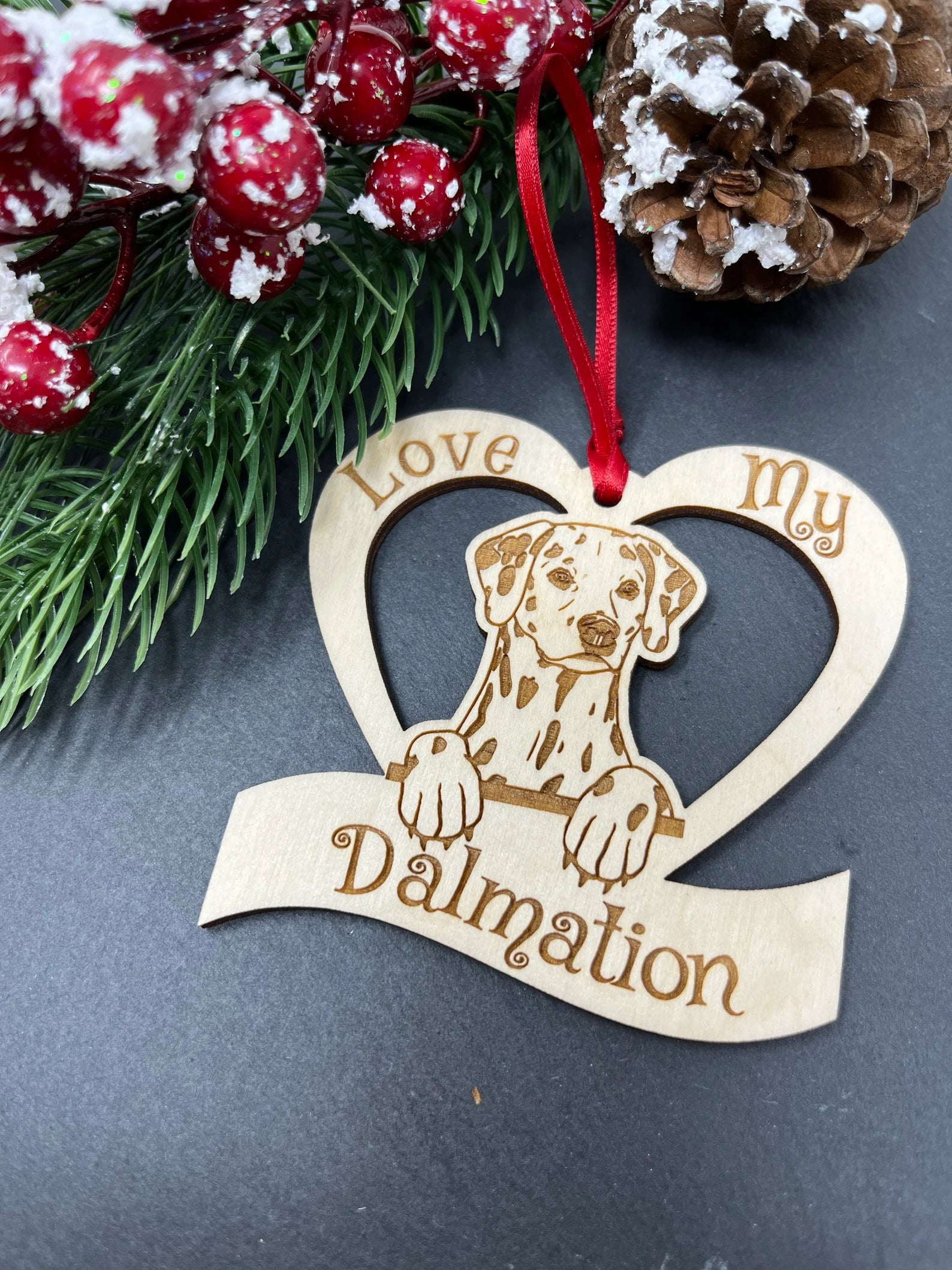 Love My Dalmatian Christmas ornament made of laser engraved Baltic Birch wood, featuring a unique design and attached ribbon for hanging.