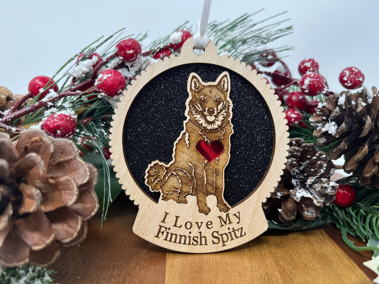 A beautifully crafted laser-cut wooden ornament featuring a Finnish Spitz silhouette, perfect for holiday decor.