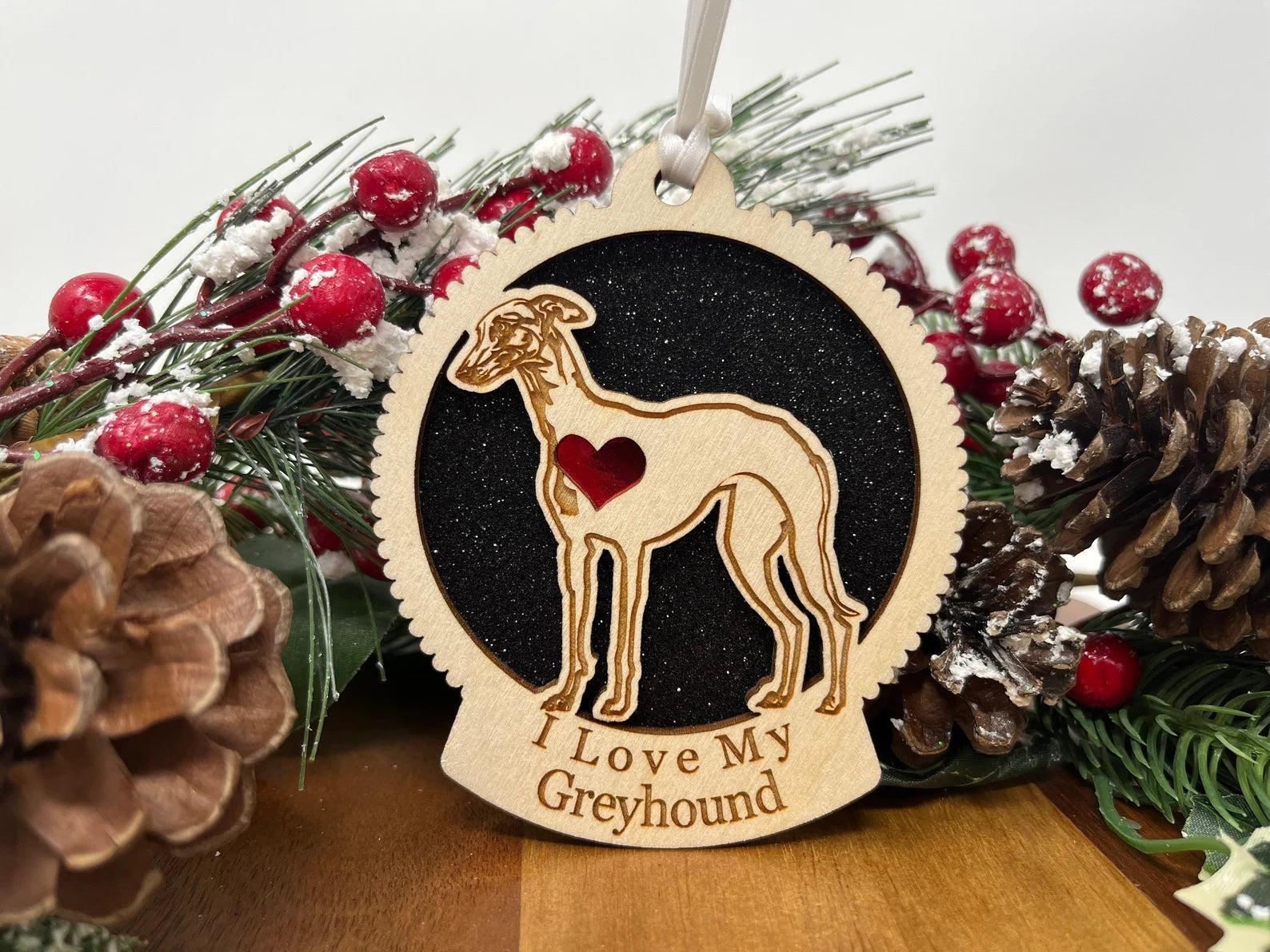 A beautifully crafted wooden ornament featuring a greyhound silhouette, perfect for Christmas decoration.