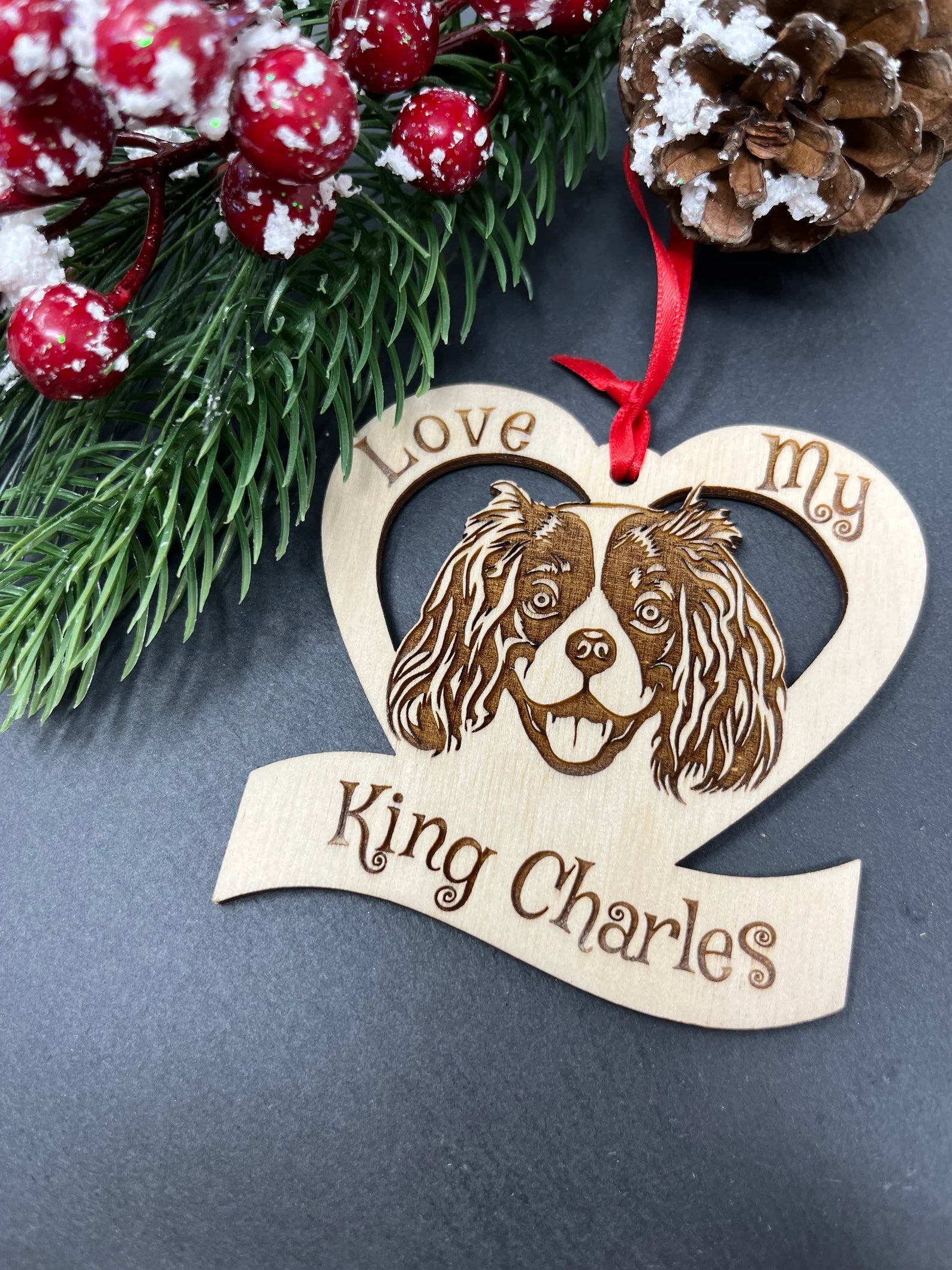 Laser engraved wooden ornament featuring a King Charles Spaniel design, perfect for Christmas decoration.