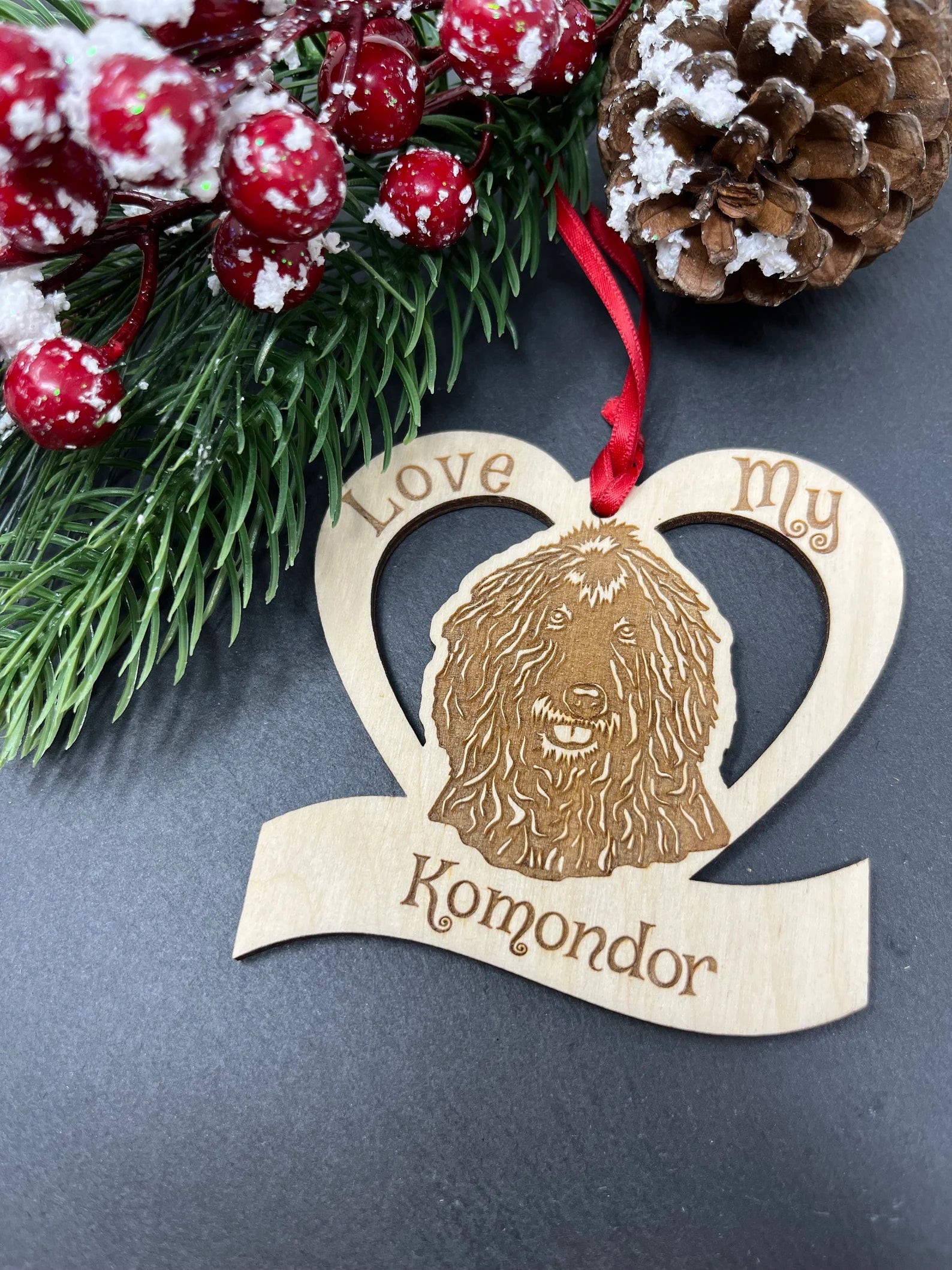 Love My Komondor ornament made from Baltic Birch wood, featuring a laser engraved design of a Komondor dog, ready to hang with a ribbon.