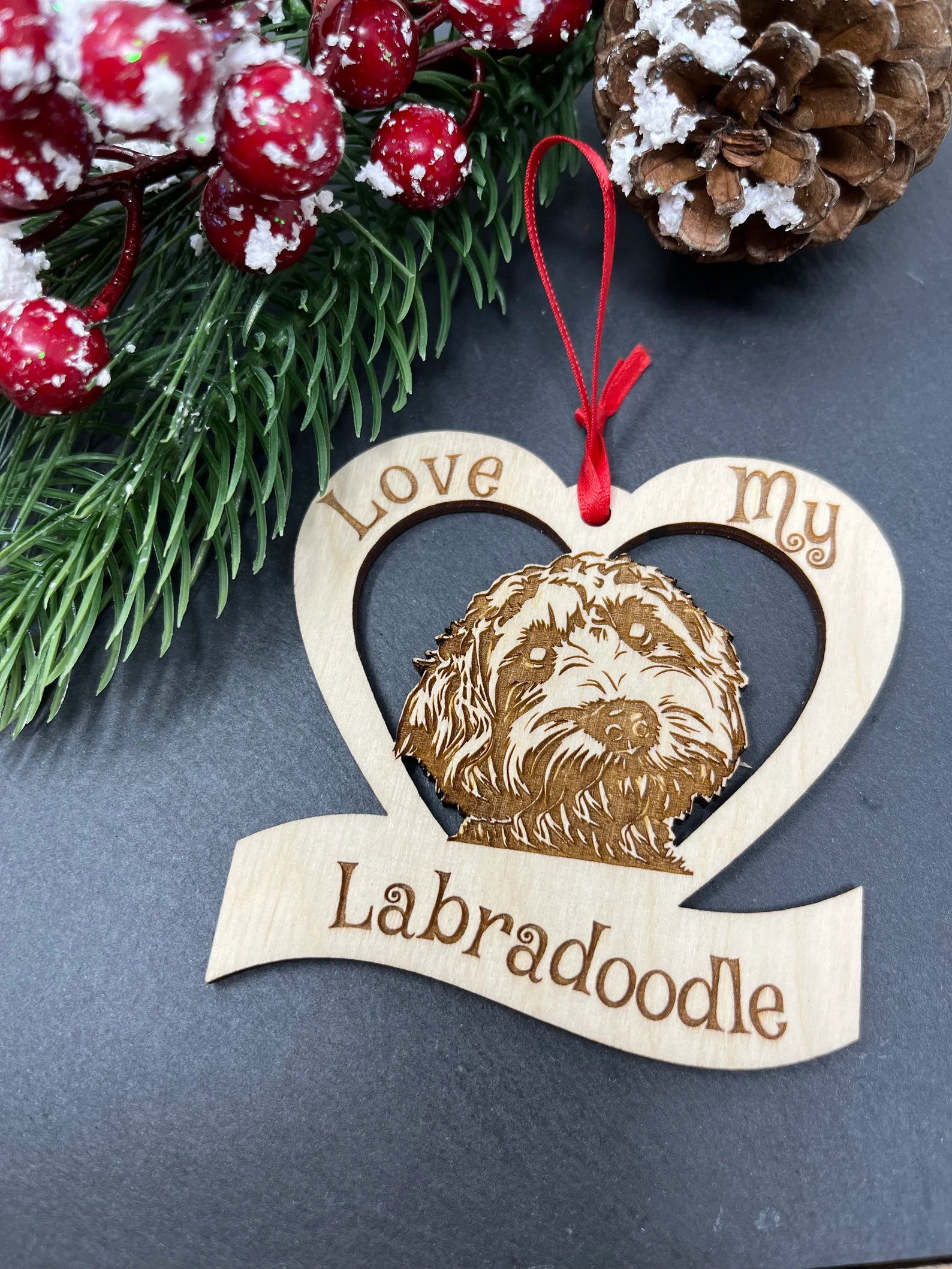 A beautifully crafted Love My Labradoodle ornament made from laser engraved Baltic Birch wood, featuring a unique design and attached ribbon for hanging.