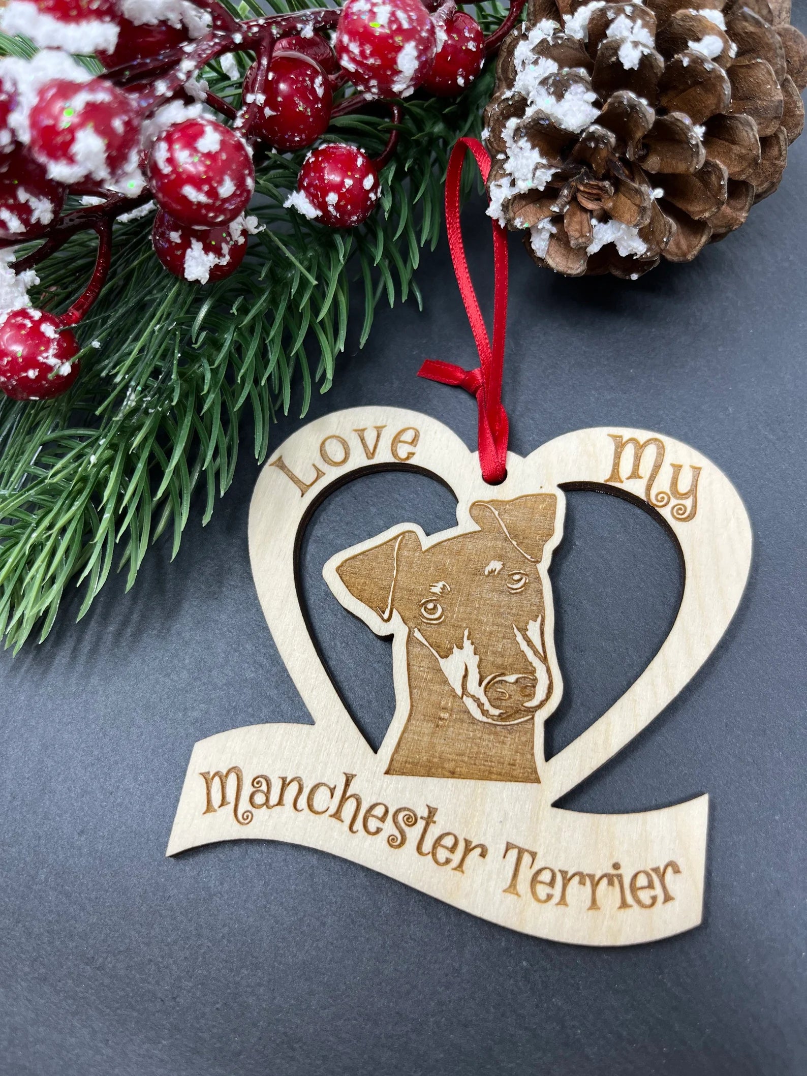 Laser engraved wooden ornament featuring a Manchester Terrier design, perfect for Christmas or as a collectible.