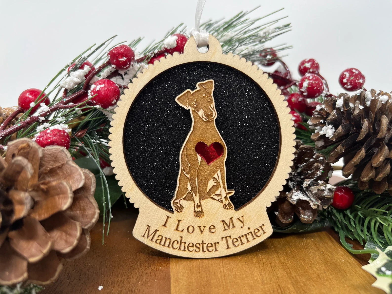 Laser cut wooden ornament featuring a Manchester Terrier silhouette, perfect for Christmas decoration.