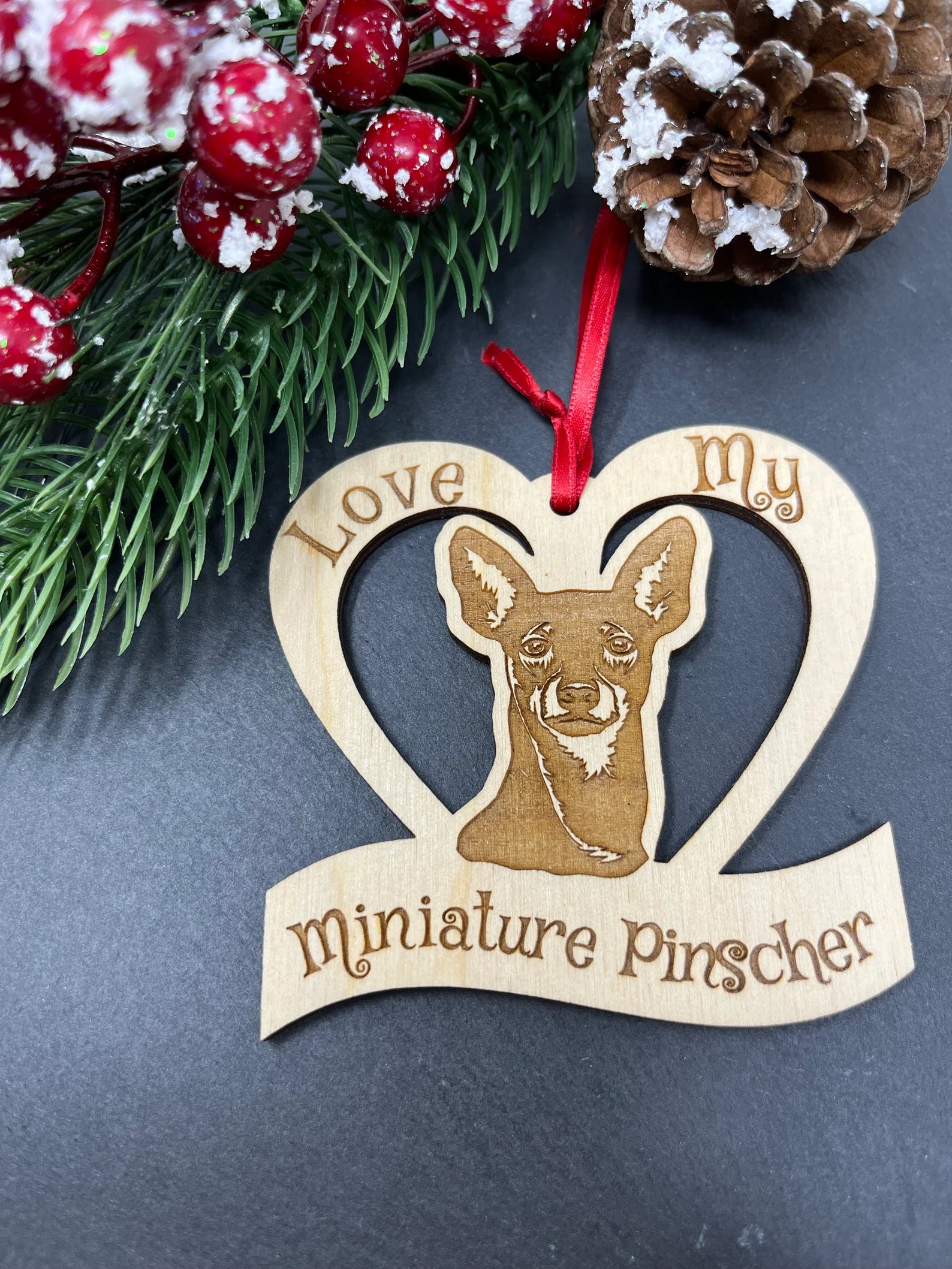 Laser engraved wooden ornament featuring a Miniature Pinscher, perfect for Christmas decoration.