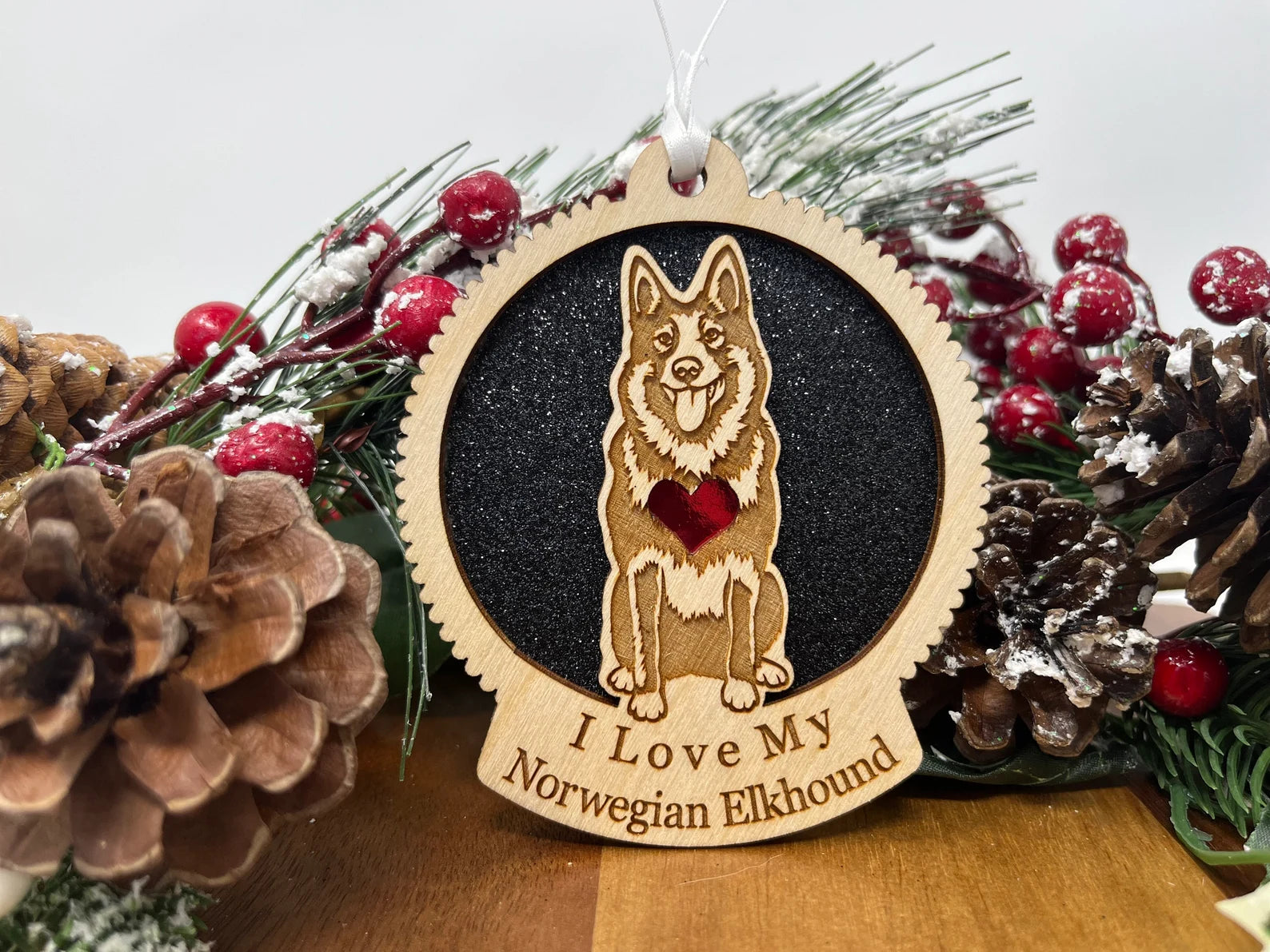 A beautifully crafted wooden ornament featuring a silhouette of a Norwegian Elkhound, perfect for Christmas decoration.