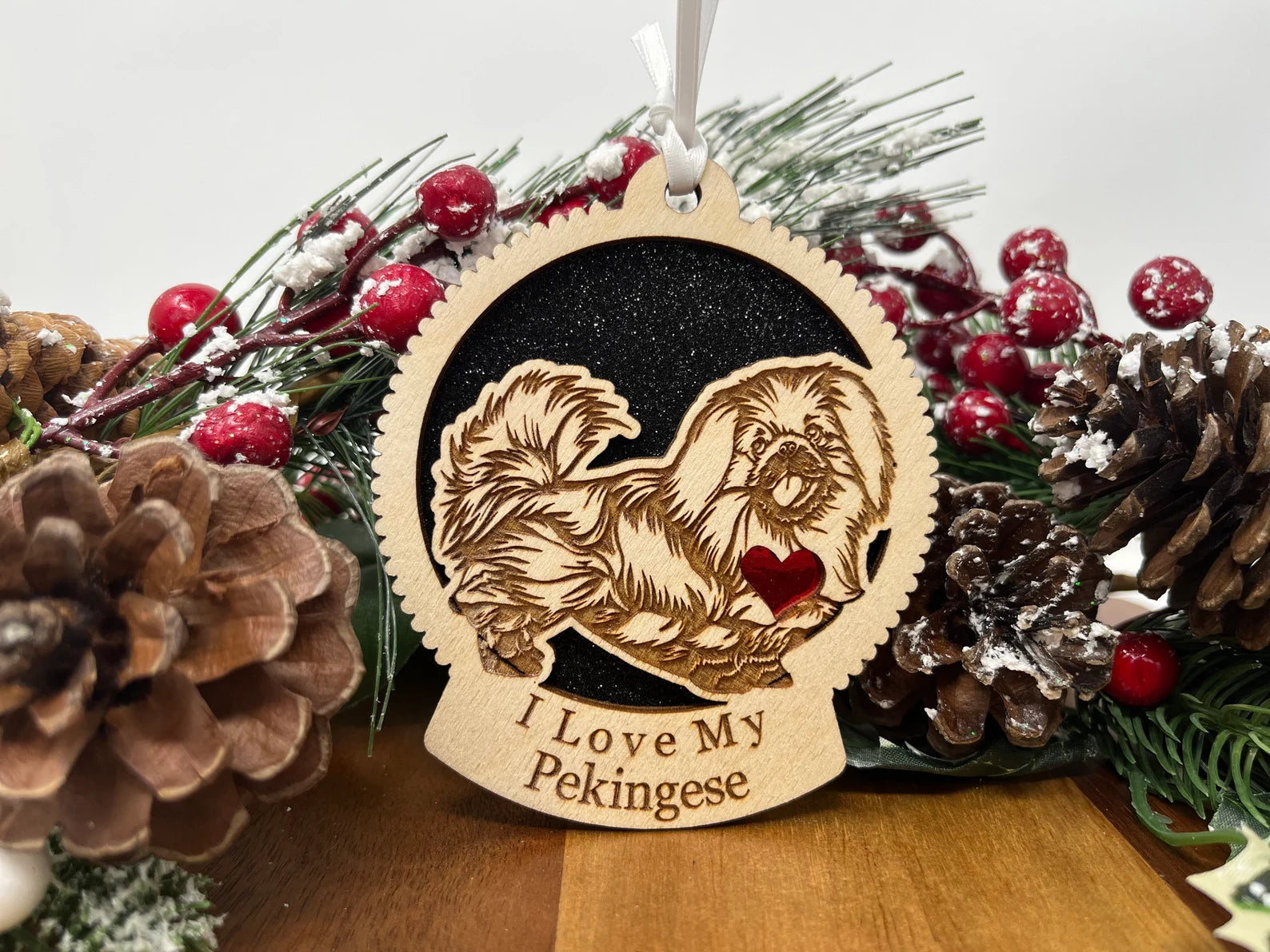 A beautifully crafted laser-cut wooden ornament featuring a Pekingese silhouette, perfect for Christmas decoration.