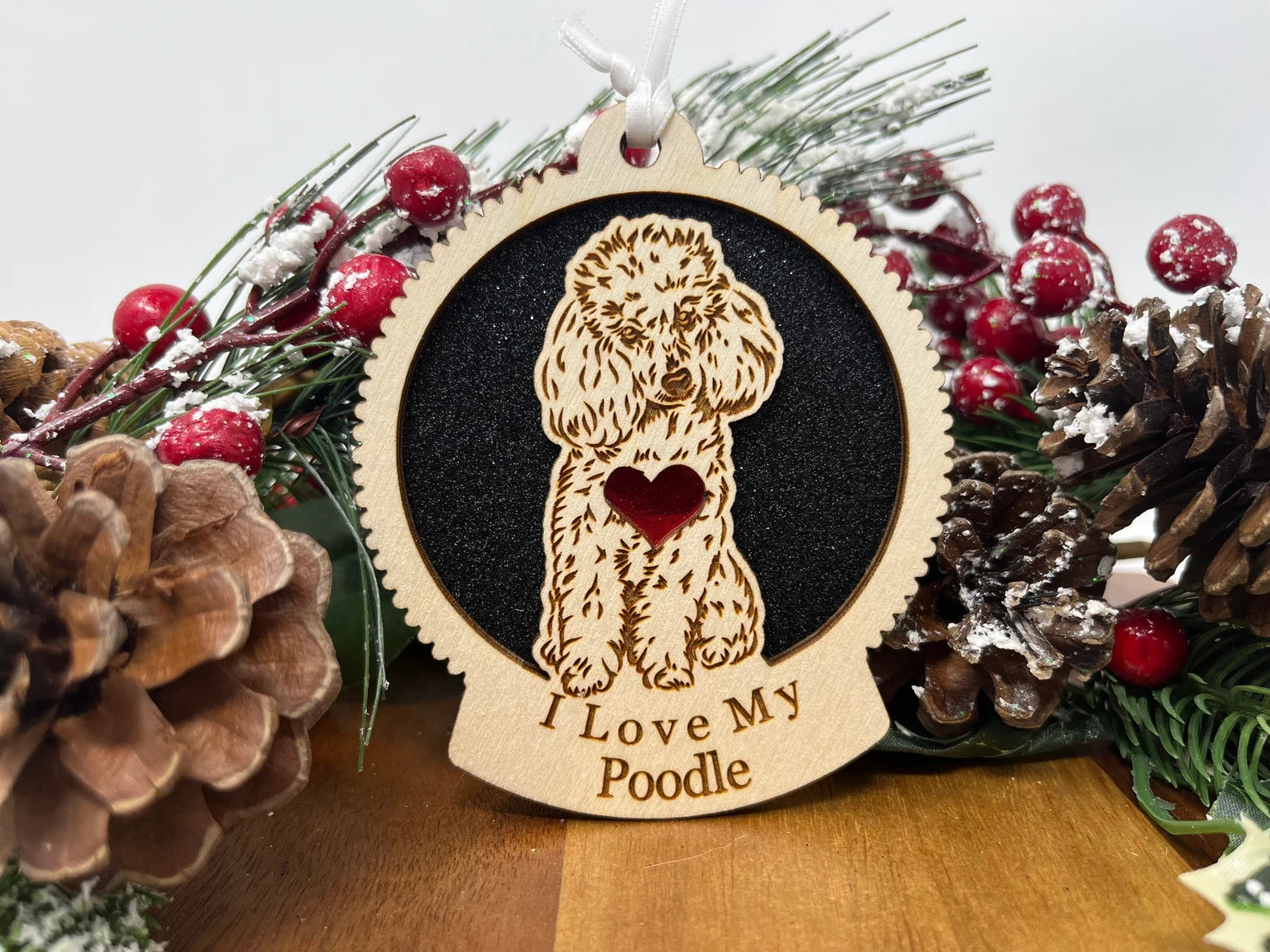 A beautifully crafted laser-cut wooden ornament featuring a poodle silhouette, perfect for Christmas decor.