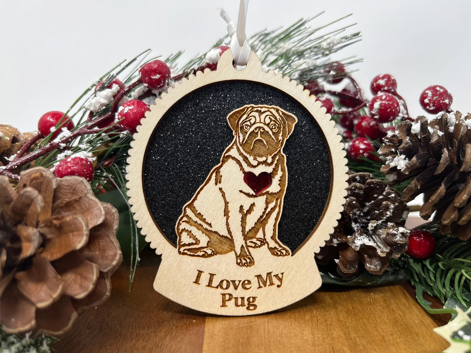 A beautifully crafted laser-cut wooden ornament featuring a pug silhouette, perfect for Christmas decoration.