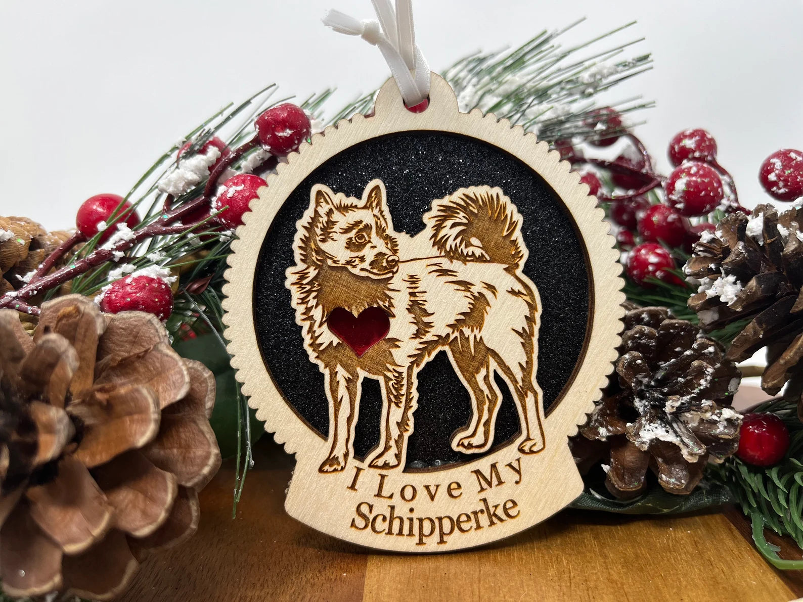 A beautifully crafted wooden ornament featuring a laser-cut silhouette of a Schipperke, perfect for holiday decor.