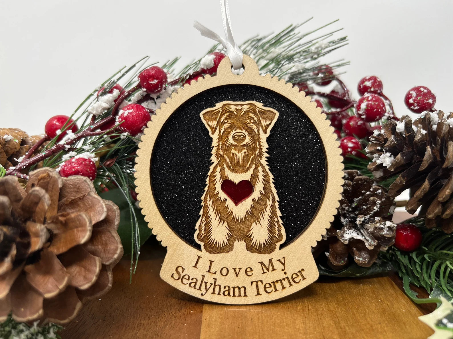 A beautifully crafted laser-cut wooden ornament featuring a Sealyham Terrier silhouette, perfect for holiday decor.