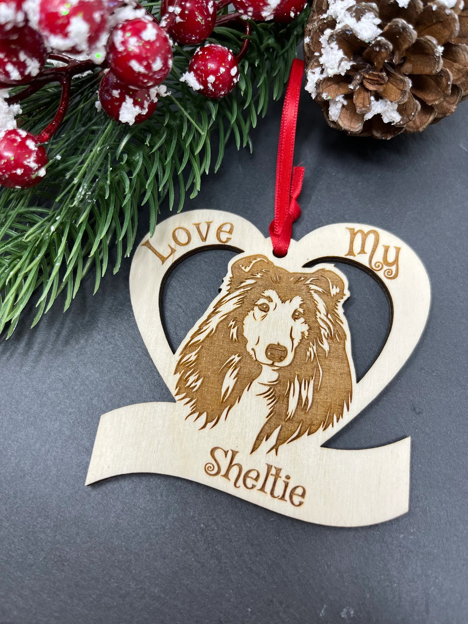 Love My Sheltie ornament made of laser engraved Baltic Birch wood, featuring a detailed design of a Sheltie, ready to hang with a ribbon.