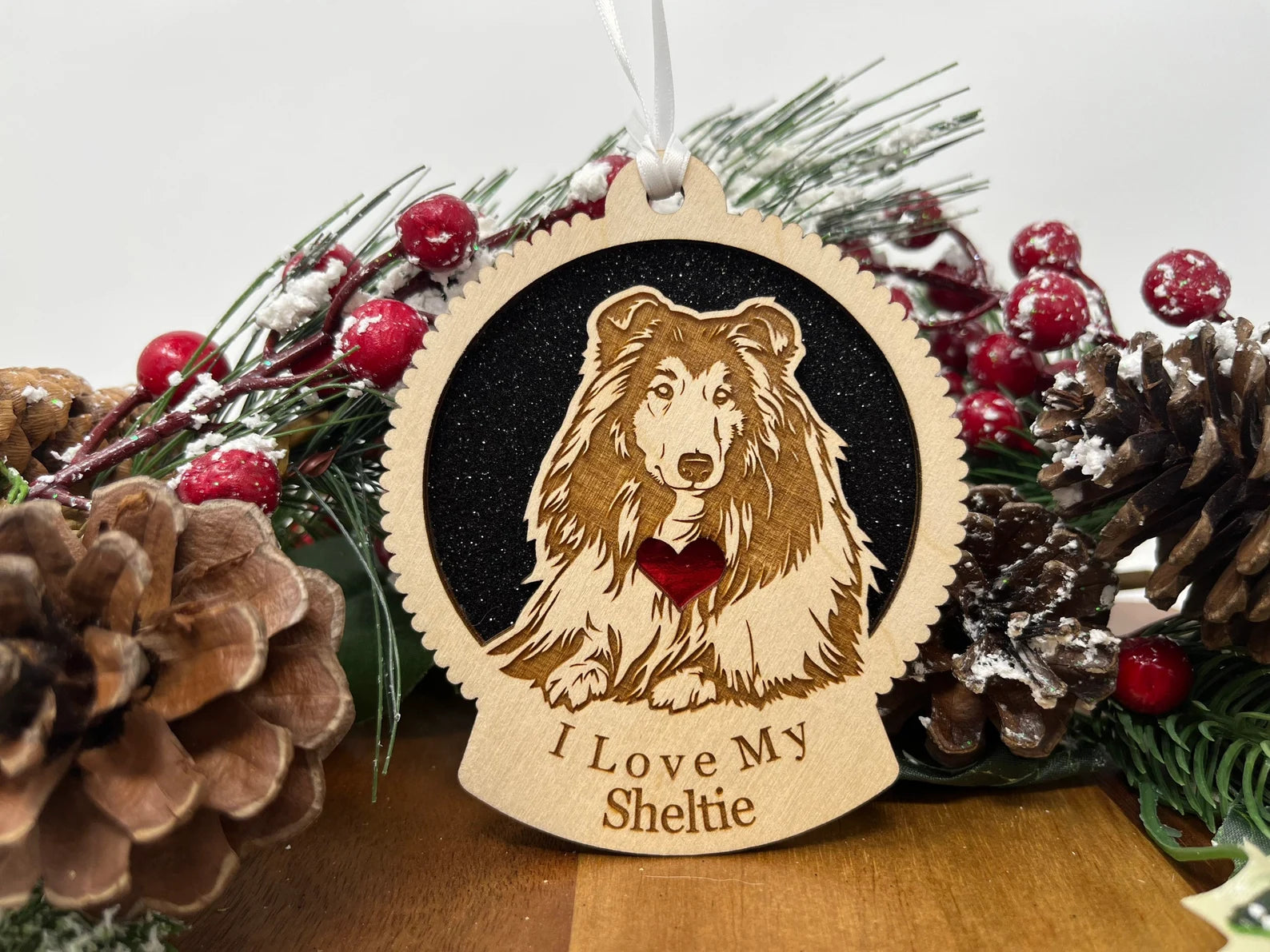 A beautifully crafted wooden ornament featuring a silhouette of a Sheltie, perfect for Christmas decoration.