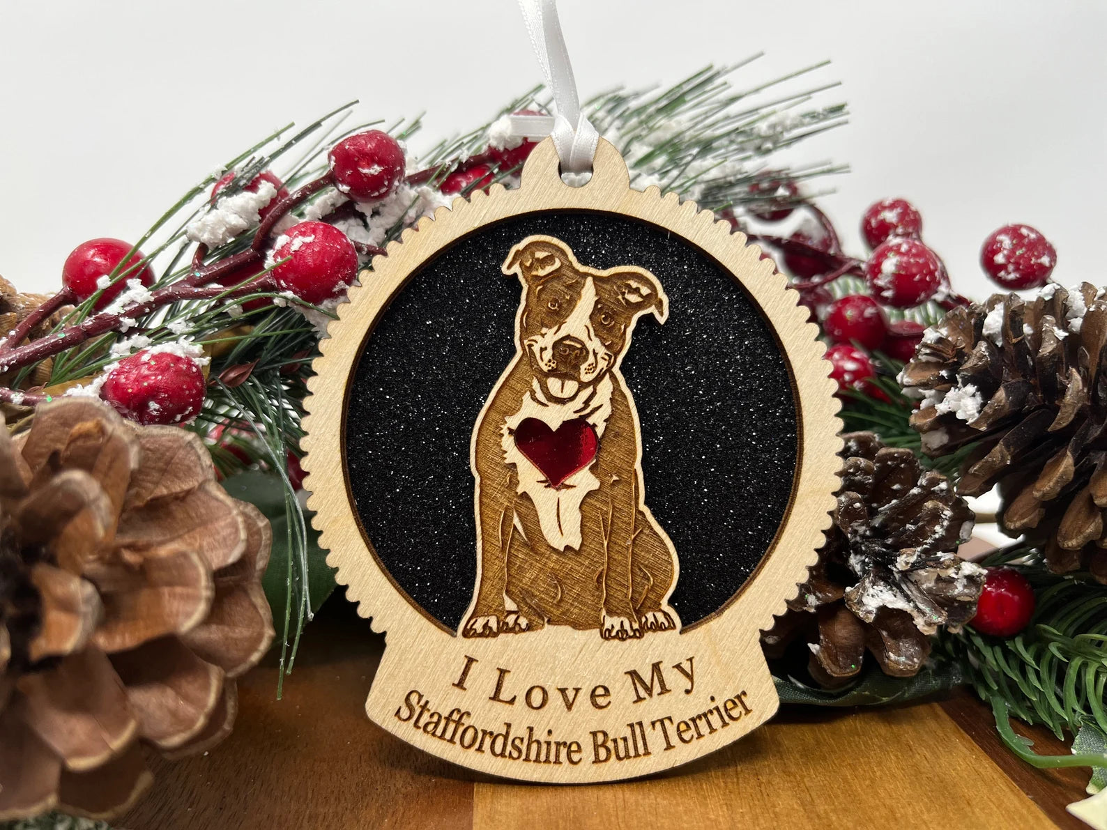 A beautifully crafted wooden ornament featuring a Staffordshire Bull Terrier silhouette, perfect for holiday decor.