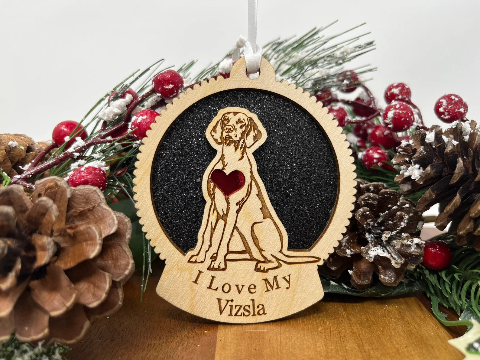 A beautifully crafted wooden ornament featuring a laser-cut silhouette of a Vizsla, perfect for holiday decor.