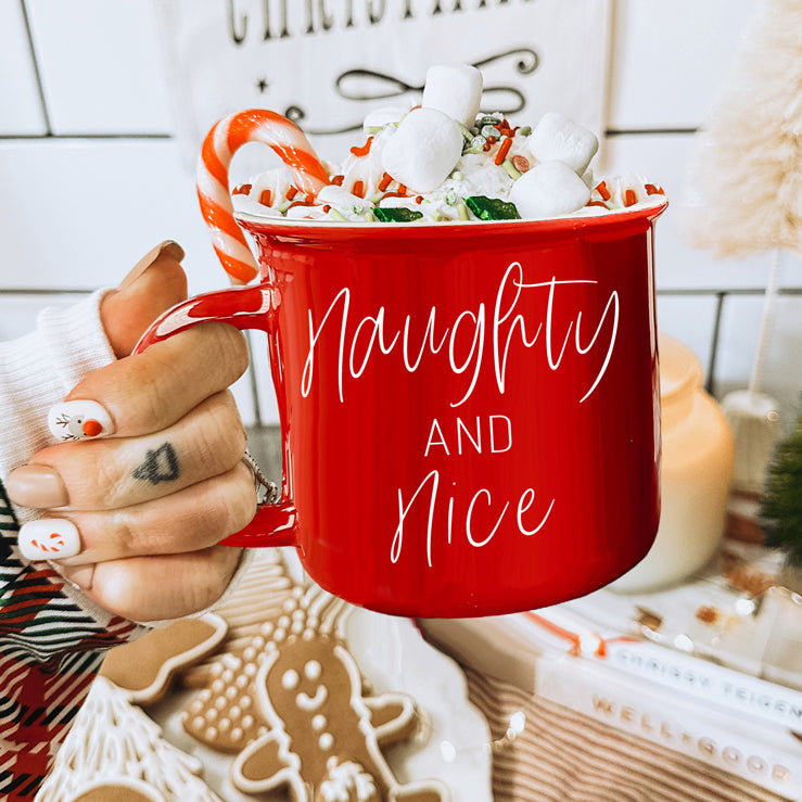 A vibrant Naughty & Nice Mug in red and green ceramic, featuring playful white lettering on both sides, perfect for coffee lovers.