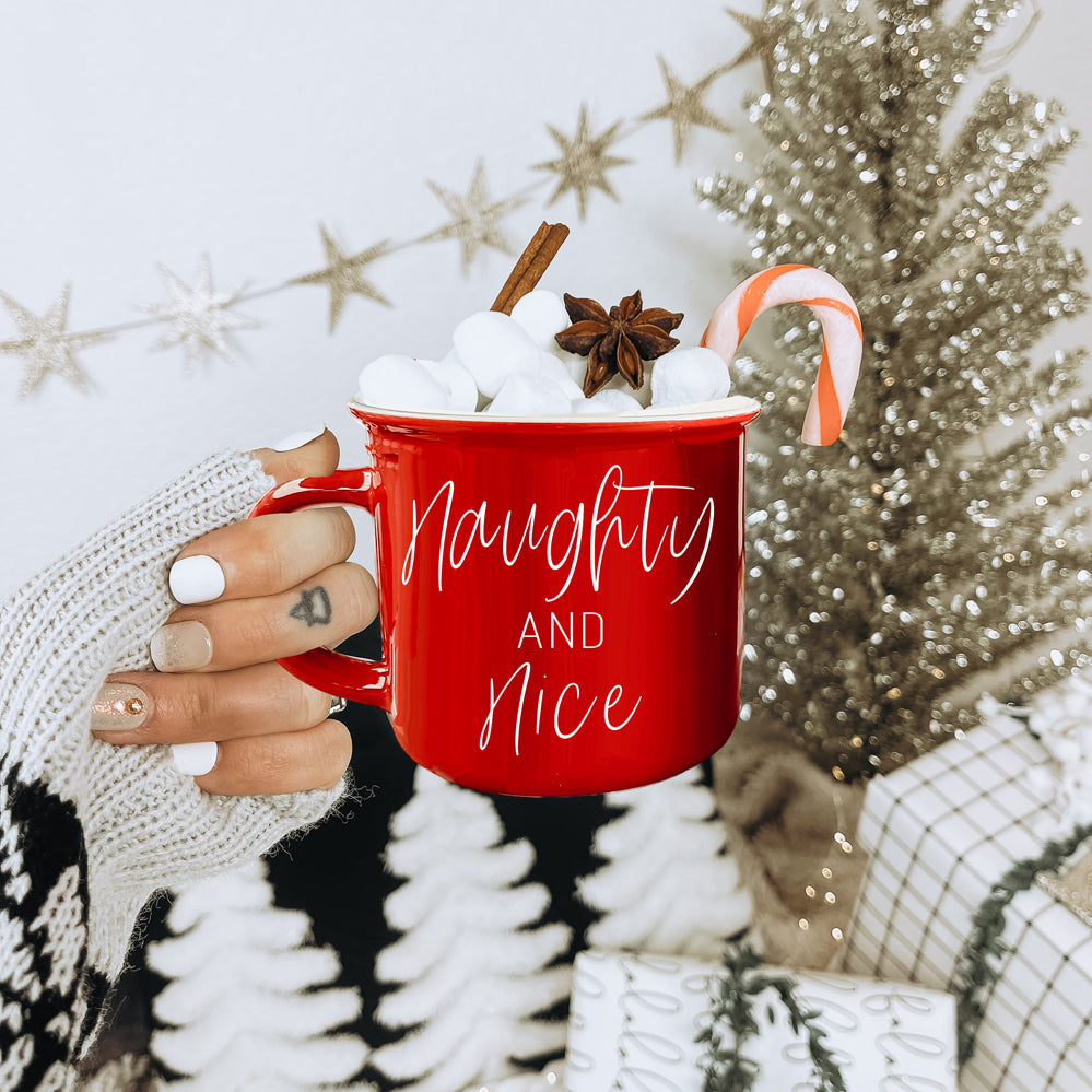 A vibrant Naughty & Nice Mug in red and green ceramic, featuring playful white lettering on both sides, perfect for coffee lovers.