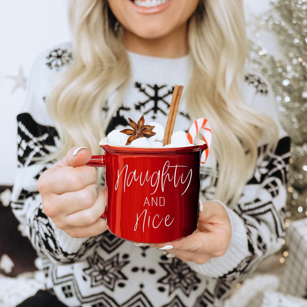 A vibrant Naughty & Nice Mug in red and green ceramic, featuring playful white lettering on both sides, perfect for coffee lovers.