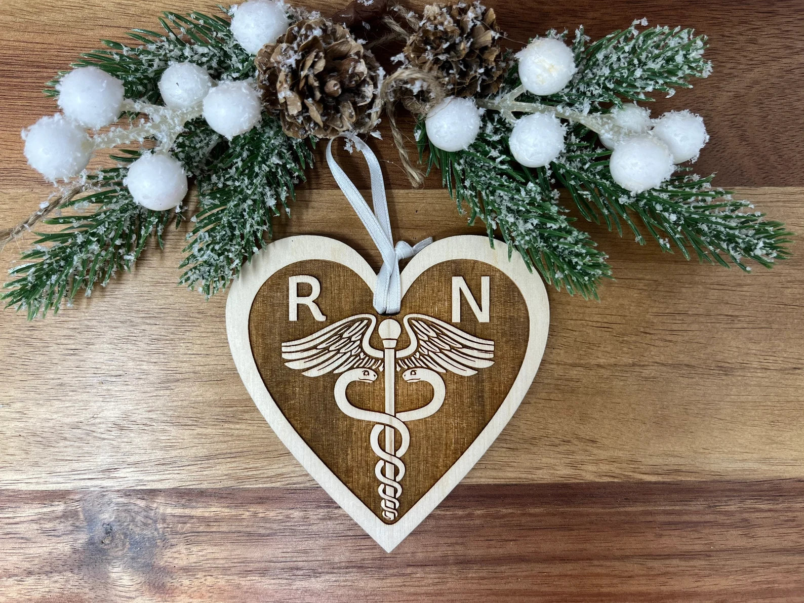 A beautifully handcrafted wooden ornament featuring the letters RN, measuring approximately 4 inches in diameter, perfect for celebrating nurses.