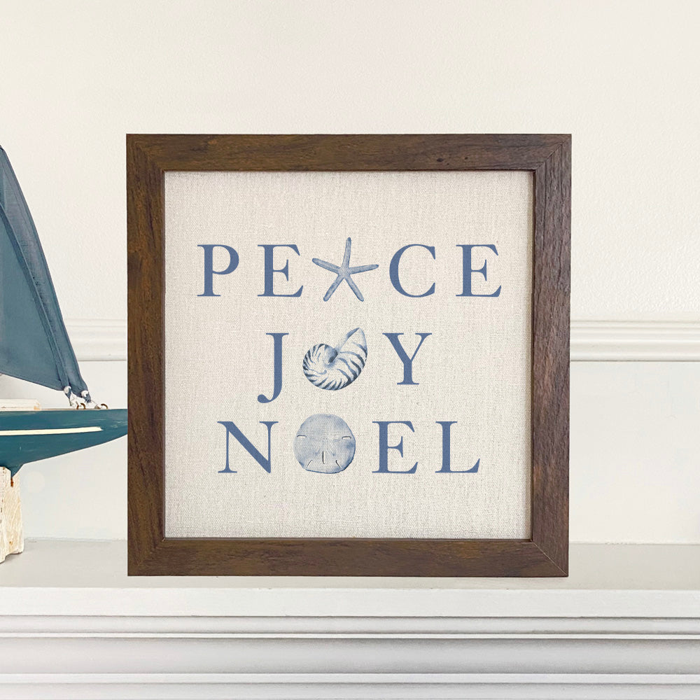 Peace Joy Noel framed sign with a stylized wood frame, eco-friendly ink printing on a linen-look background, available in walnut and white-washed finishes.