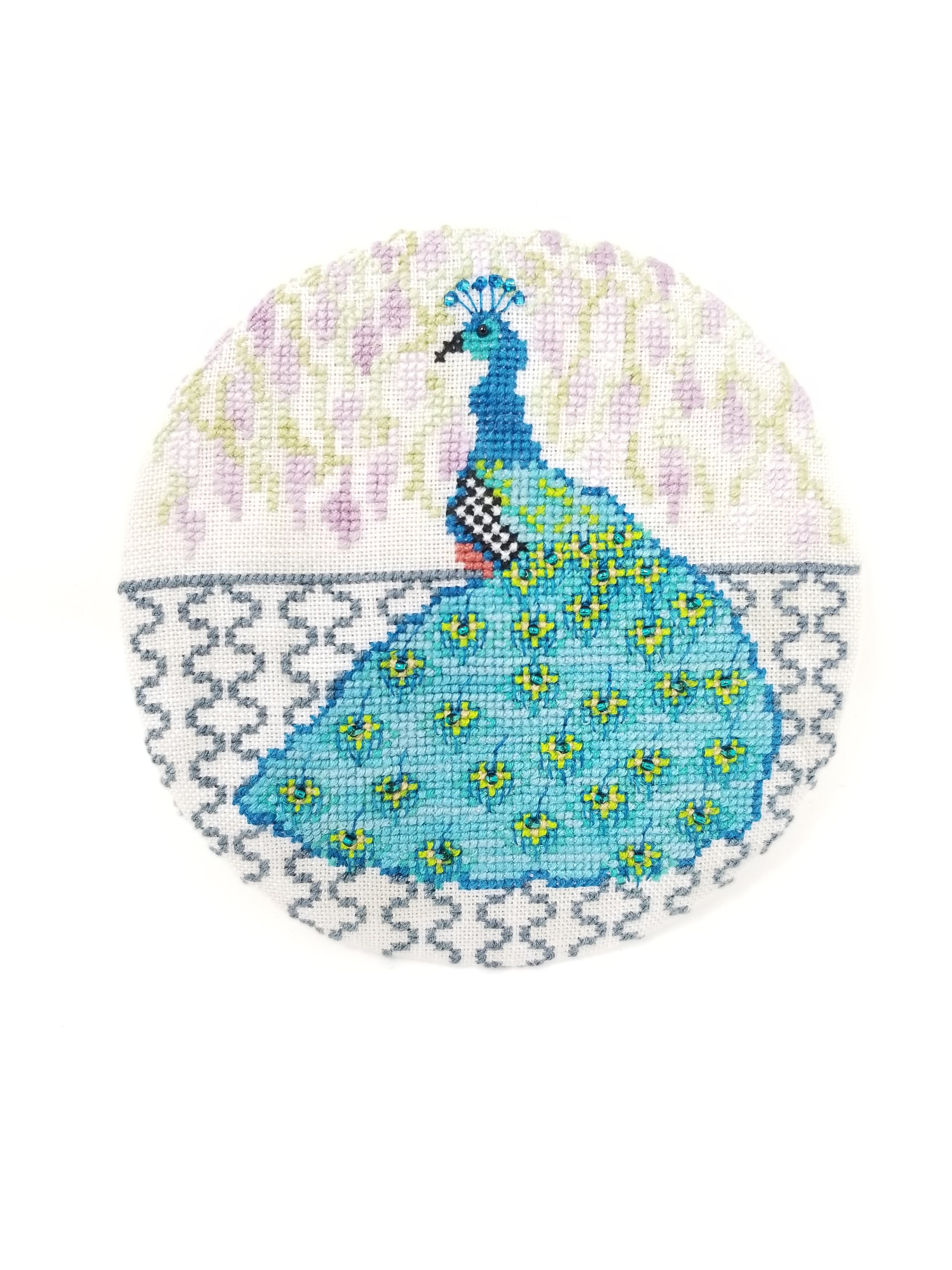 Peacock Prince cross-stitch pattern designed by Suzzanne Brakefield, featuring vibrant colors and intricate details.