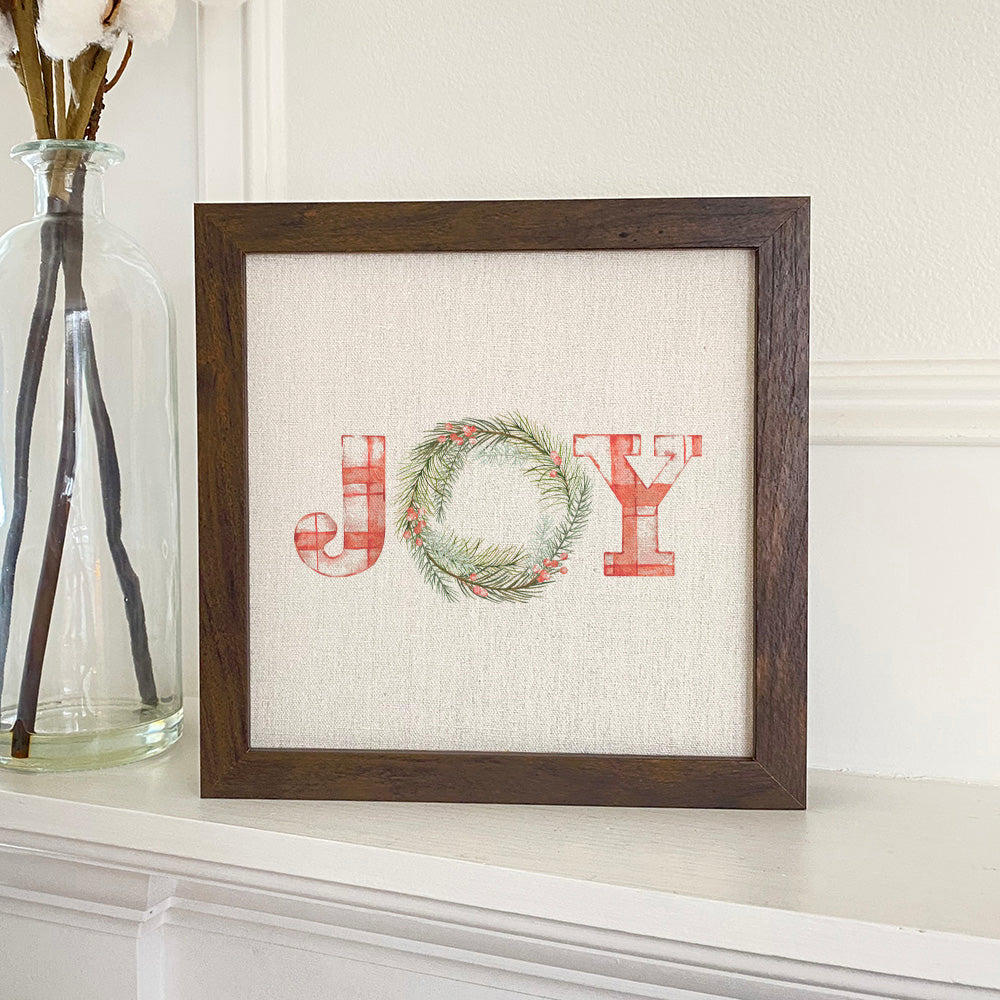 Plaid Joy Wreath framed sign with a wood frame, featuring a linen-look background and eco-friendly printing.