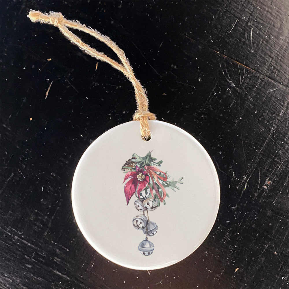 A beautifully crafted porcelain ornament featuring Poinsettia Bells design, perfect for holiday decor or as a gift tag.