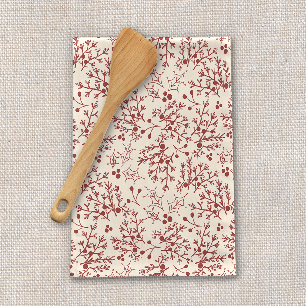 A vibrant red tea towel featuring a Christmas branch design, made from durable cotton twill, perfect for festive kitchen decor.