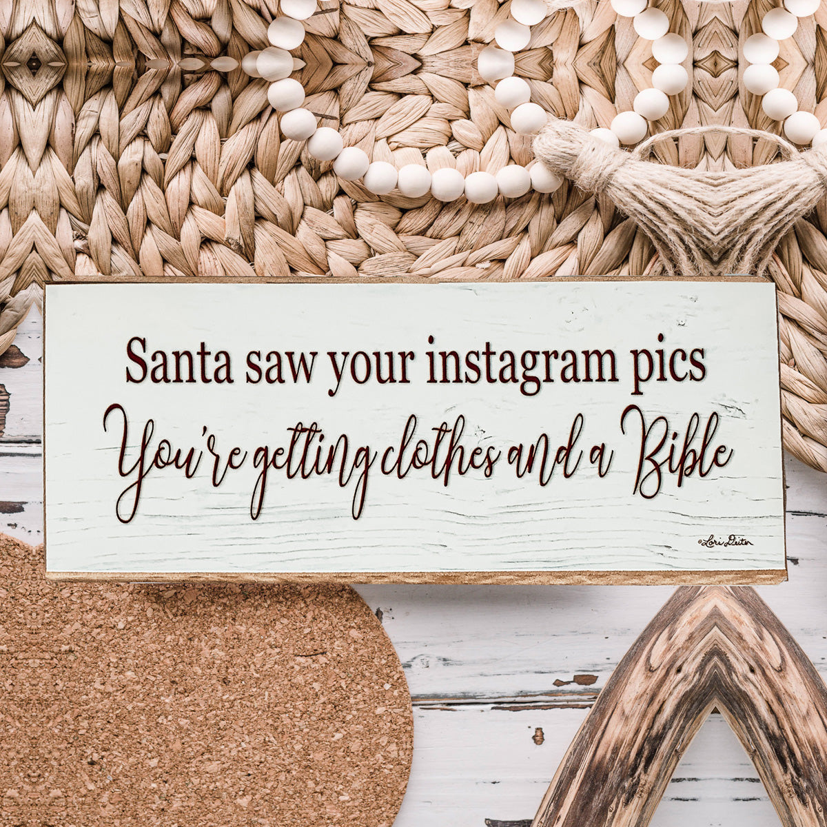 A humorous wooden sign reading 'Santa Seen Your Instagram & He’s Getting You Clothes & a Bible', perfect for holiday decor.