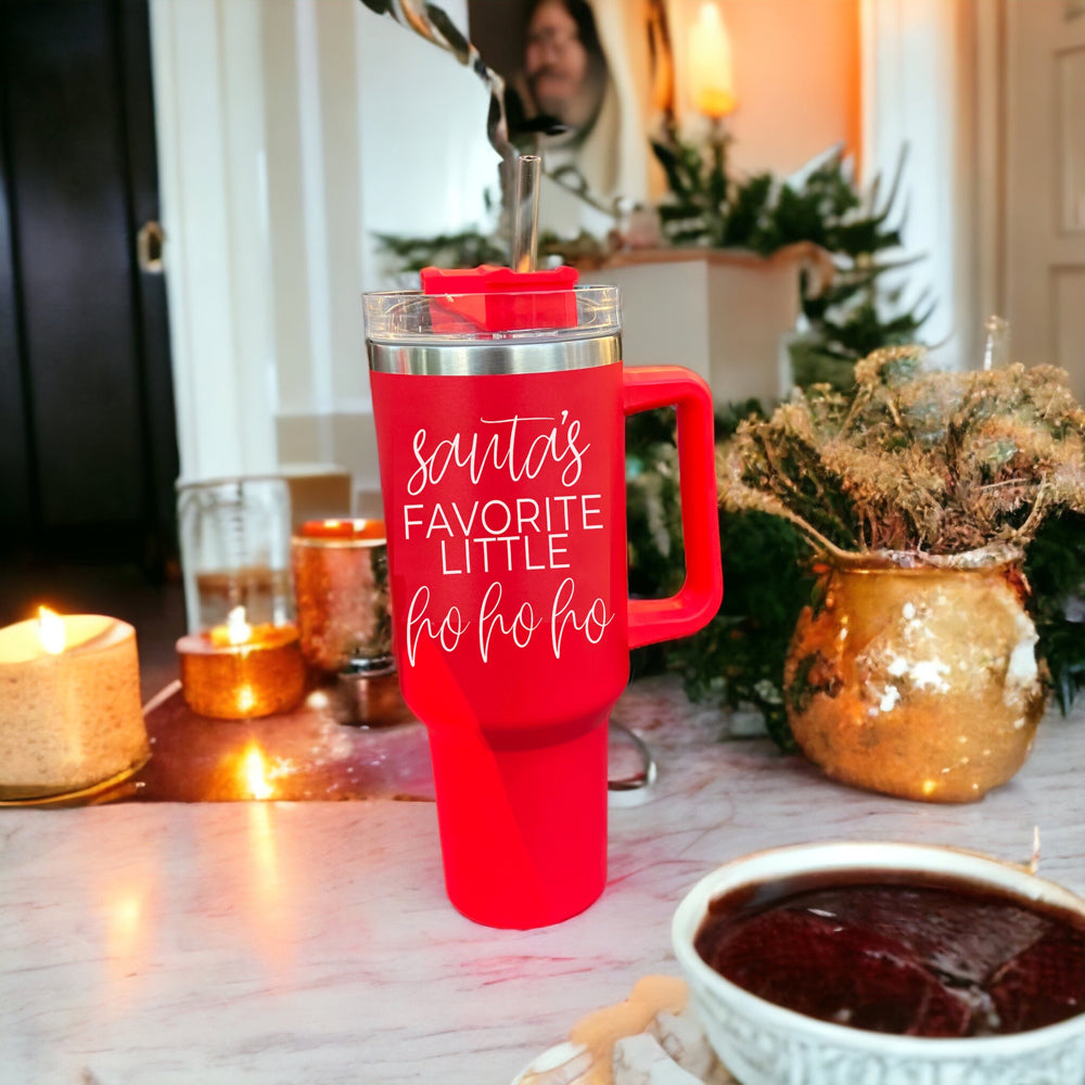 Santa's Ho 40oz insulated mug with a red exterior, featuring a humorous Santa graphic, lid, straw, and handle.