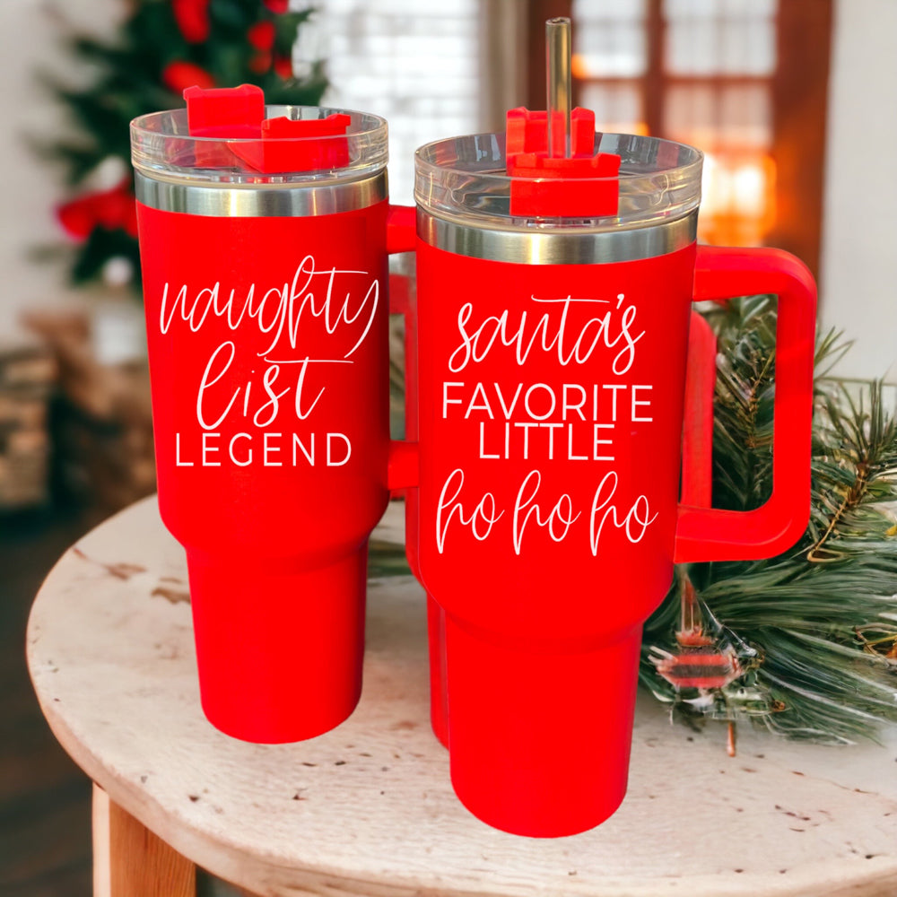 Santa's Ho 40oz insulated mug with a red exterior, featuring a humorous Santa graphic, lid, straw, and handle.