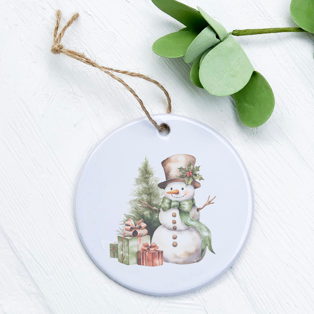 A beautifully crafted porcelain ornament featuring a snowman and presents, showcasing vibrant colors and a glossy finish.