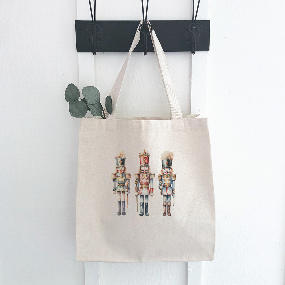 Three Nutcrackers Canvas Tote Bag featuring vibrant design and durable straps, perfect for shopping.