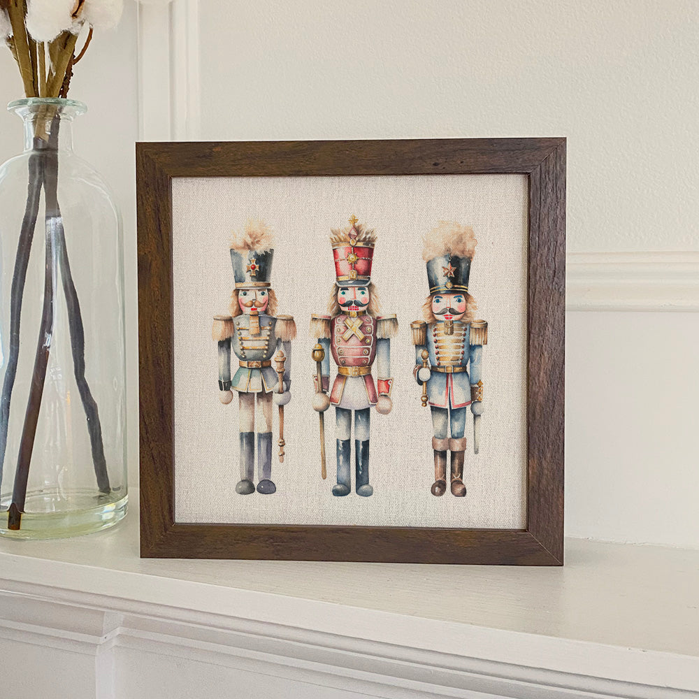 Three Nutcrackers framed sign with a stylized wood frame, featuring eco-friendly printing on a linen-look background.