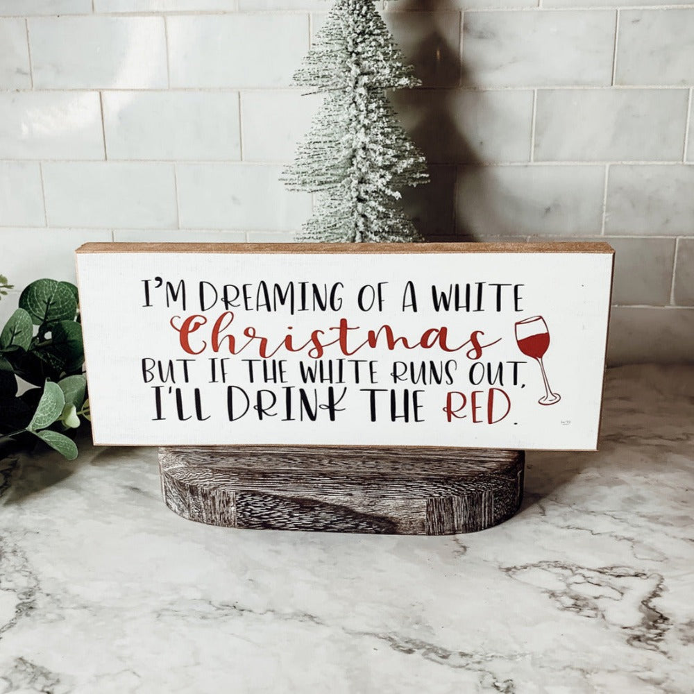 A handmade wooden sign featuring a humorous Christmas quote about wine, designed for festive decor.