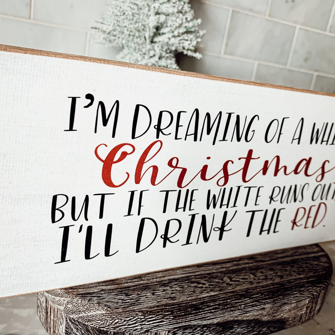 A handmade wooden sign featuring a humorous Christmas quote about wine, designed for festive decor.