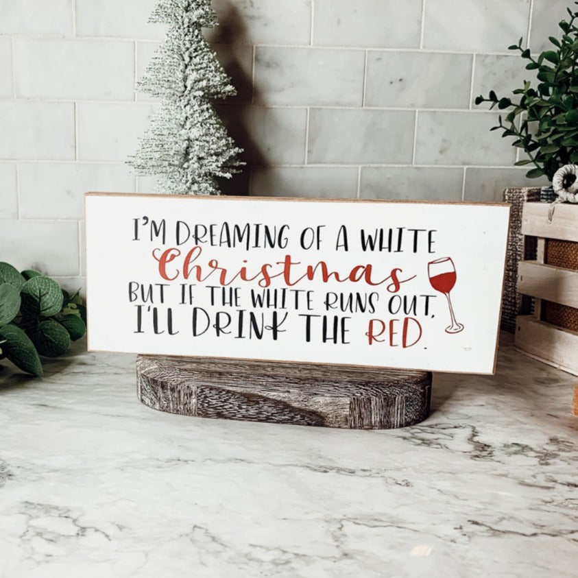 A handmade wooden sign featuring a humorous Christmas quote about wine, designed for festive decor.