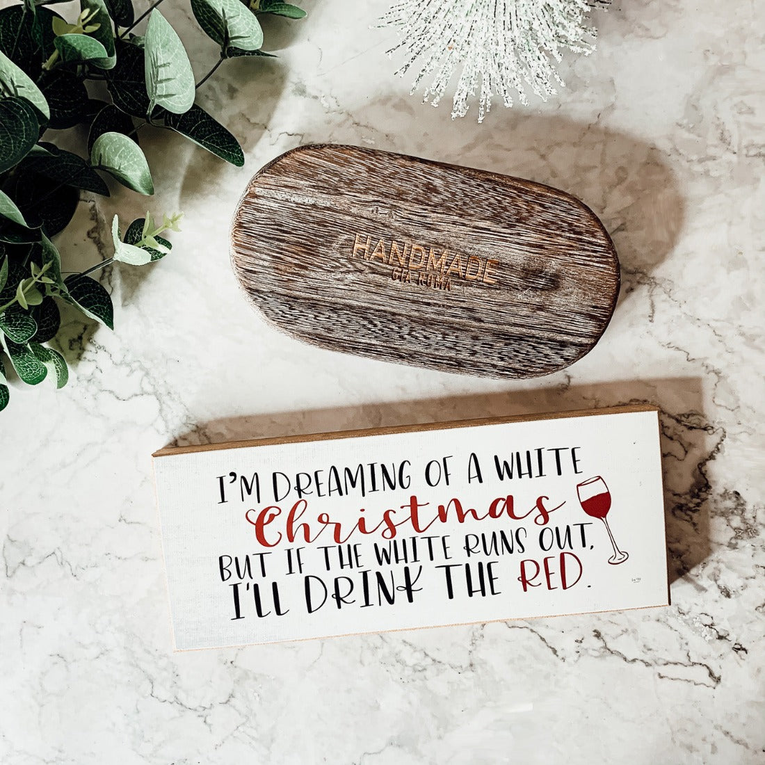 A handmade wooden sign featuring a humorous Christmas quote about wine, designed for festive decor.