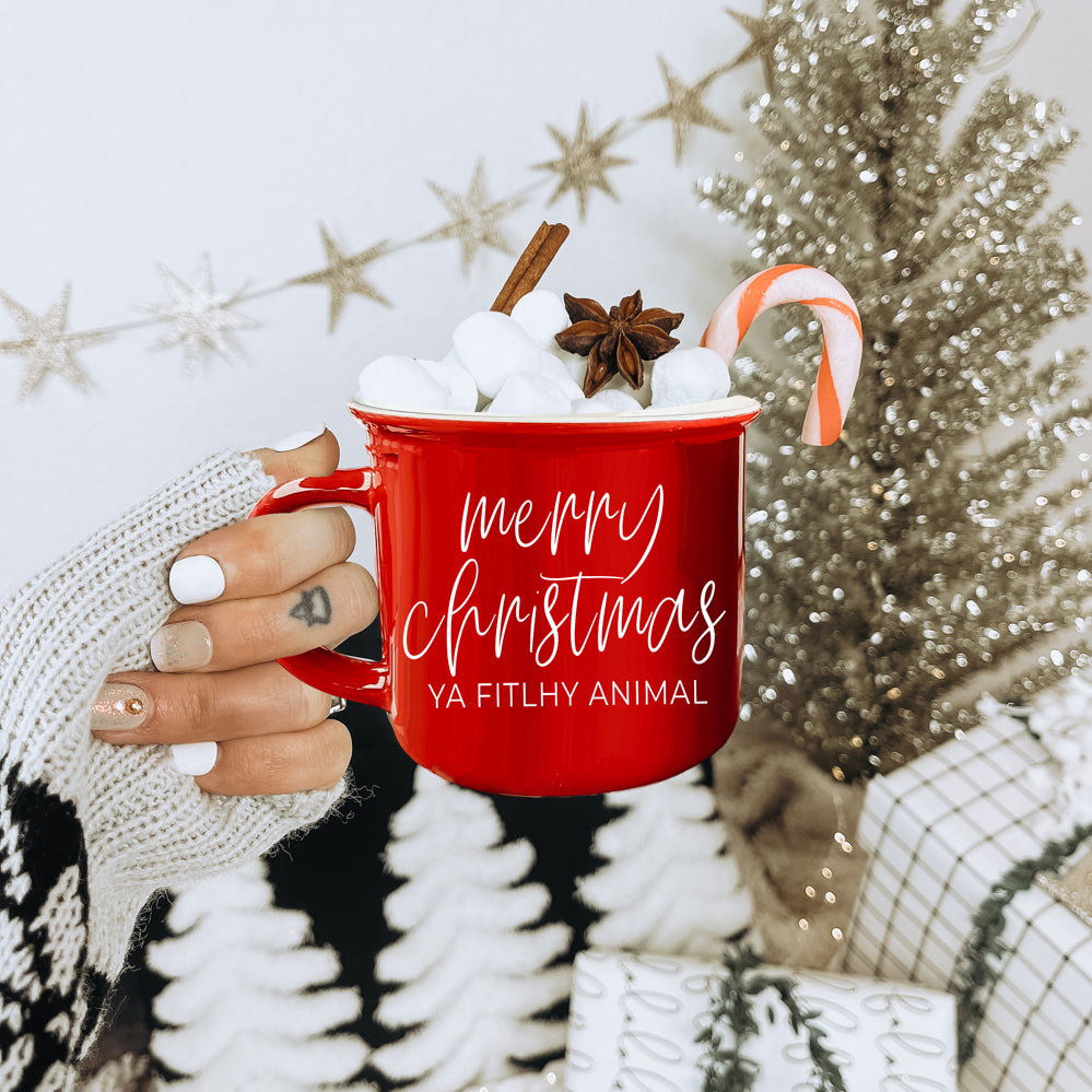 A quirky ceramic mug featuring the phrase 'Ya Filthy Animal' with the word 'Filthy' humorously misspelled as 'Fitlhy', available in red or green.