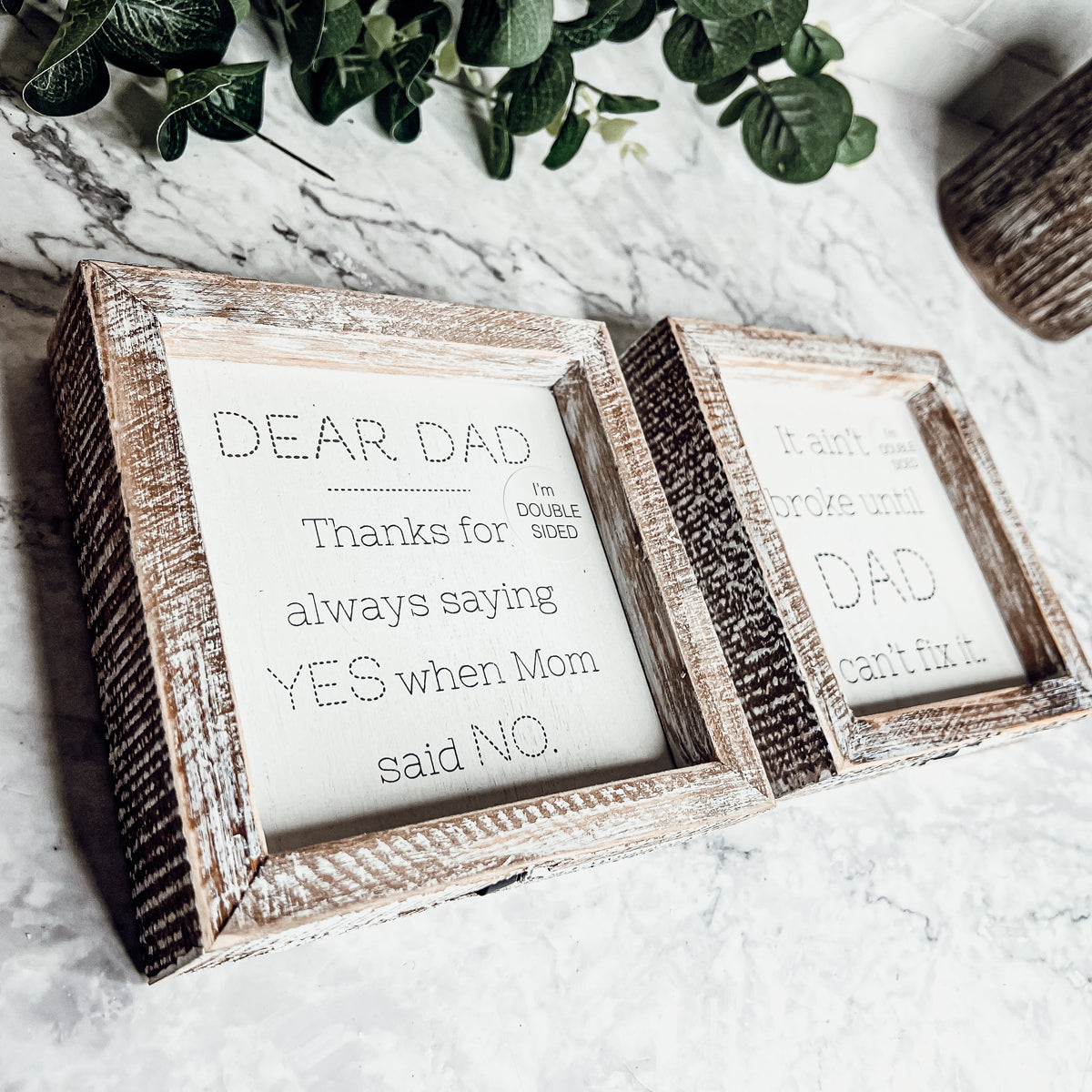 Double-sided wooden sign featuring humorous and heartfelt messages for dads, framed in rustic white wash.