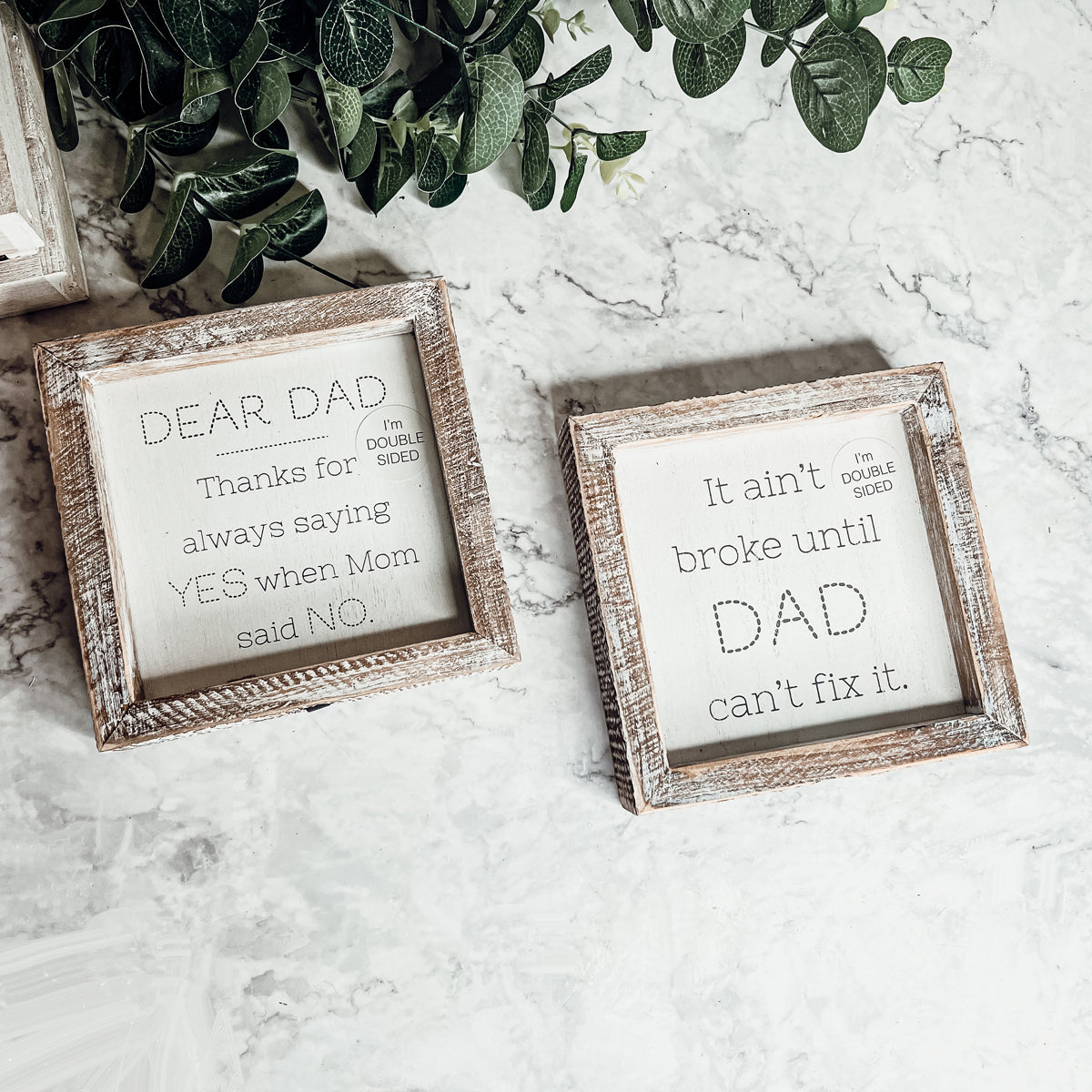 Double-sided wooden sign featuring humorous and heartfelt messages for dads, framed in rustic white wash.