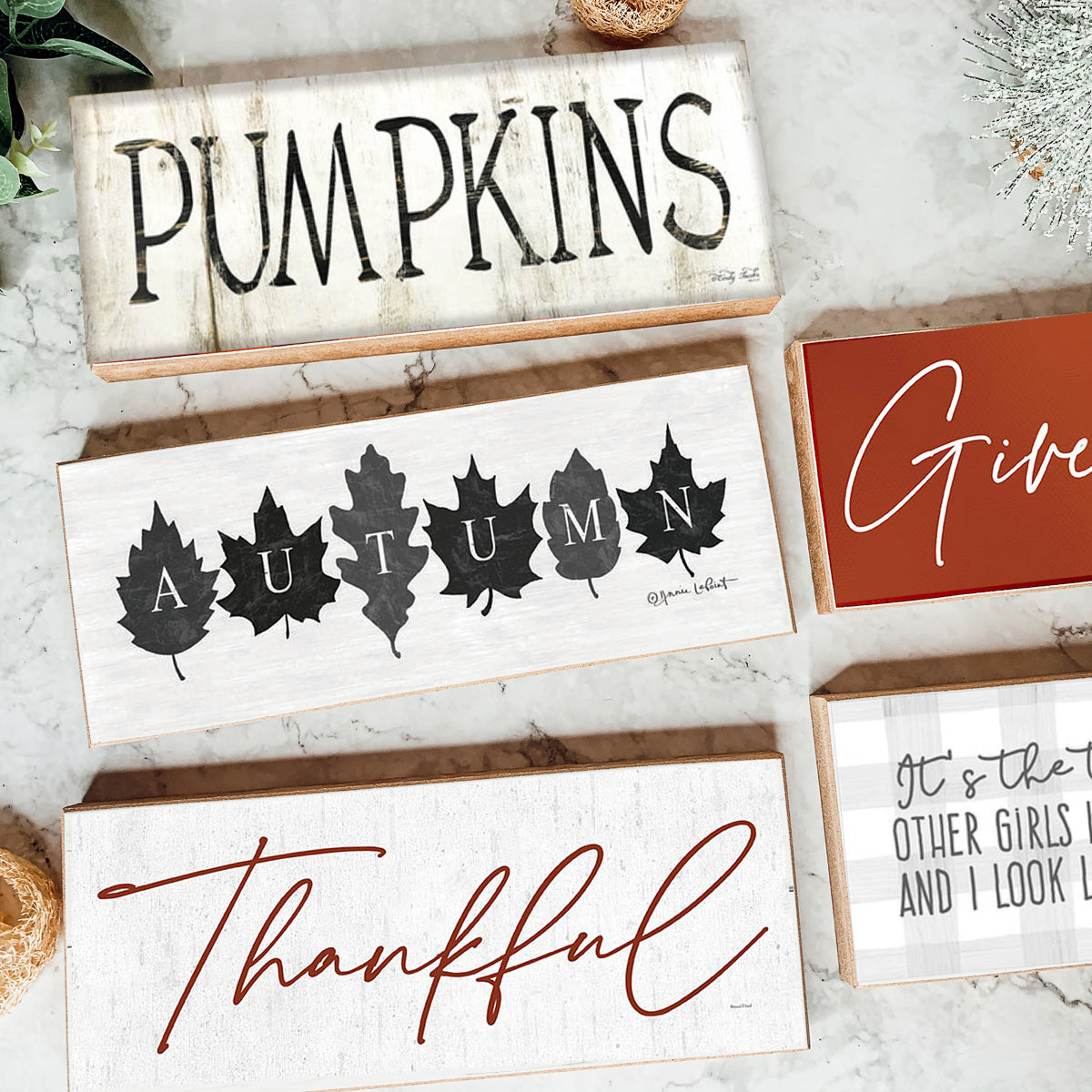 Rustic Autumn sign with off-white background and leaf designs, spelling 'Autumn' in elegant letters.